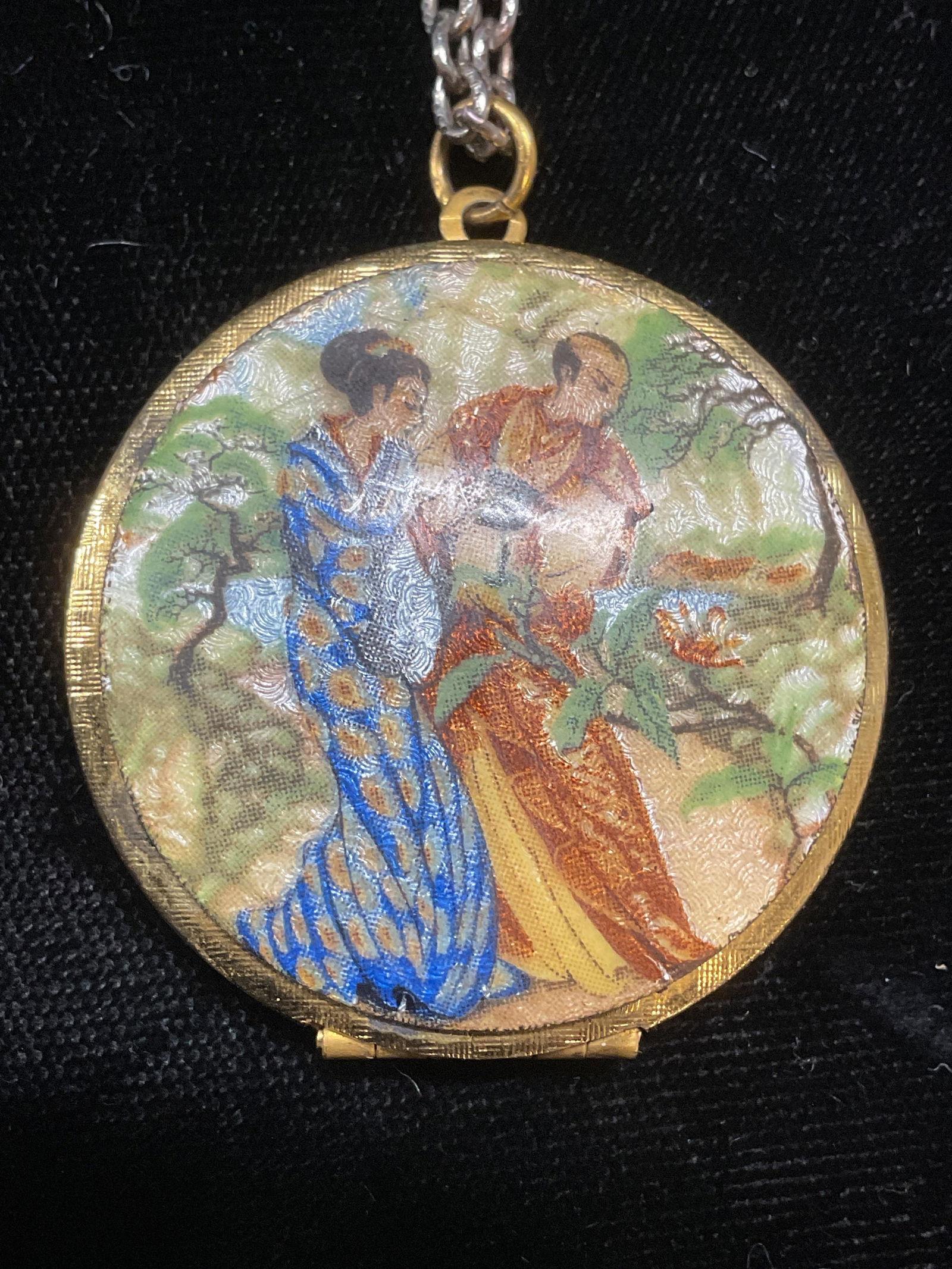 Vintage Gold Tone Enamel Couple Locket Necklace: Vintage gold tone locket with hand painted enamel figural couple motif on silver tone chain. Chain drop length approx 12 inches. Locket measures approx 1.5 inches wide. Some wear including scratching