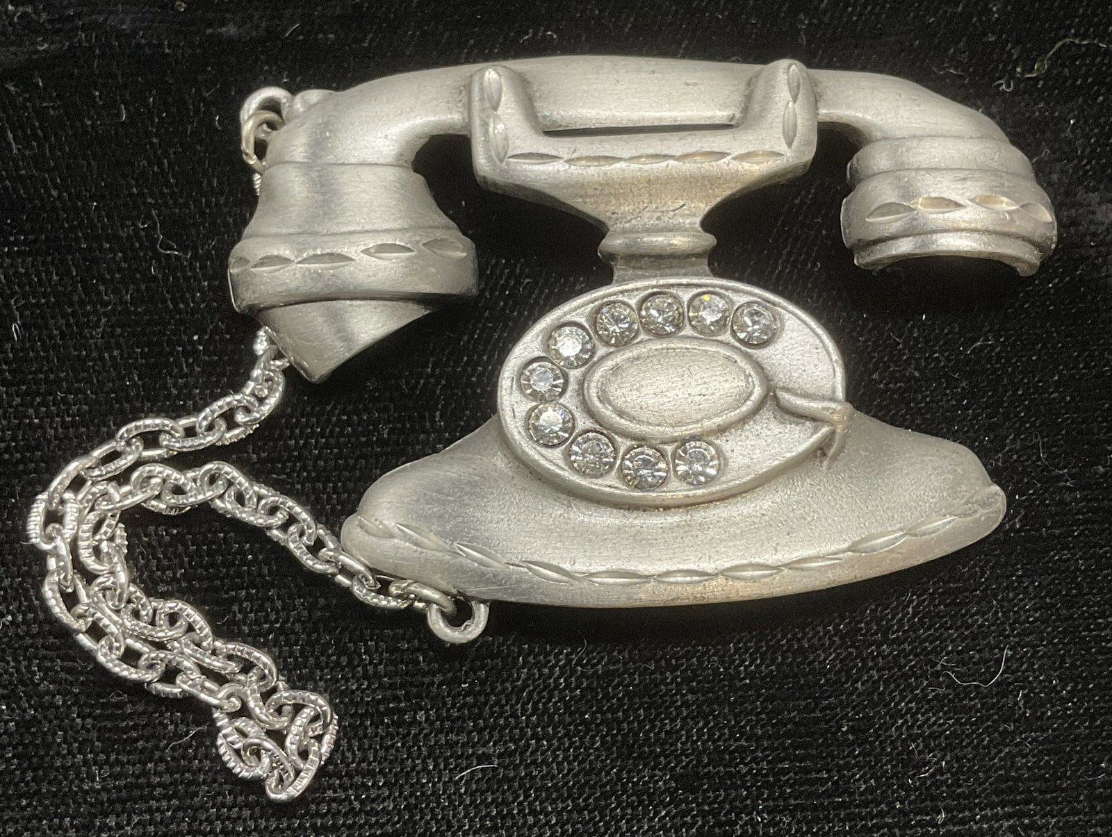 Vintage JJ Silver Tone Crystal Rotary Phone Brooch: Vintage JJ silver tone rotary phone motif brooch with crystal decoration. Signed on underside. Hinge pin on underside. Measures approx 1.5 x 2 inches. Some wear including scratching observed. Jewelry,