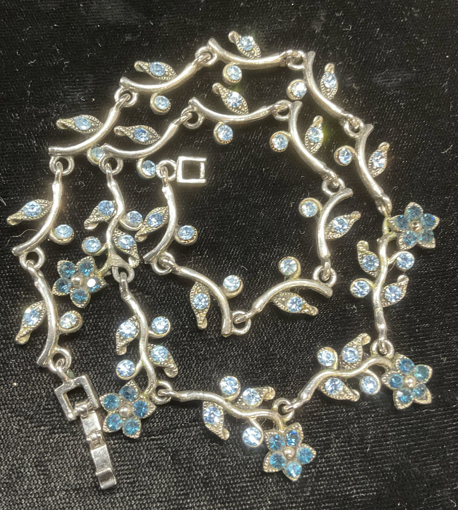 Silver Tone Blue Crystal Flower Necklace: Silver tone flower motif necklace with blue crystal decoration. Drop length approx 7.5 inches. Some wear including scratching observed. Jewelry, estate jewelry, costume jewelry, cocktail jewelry, fash
