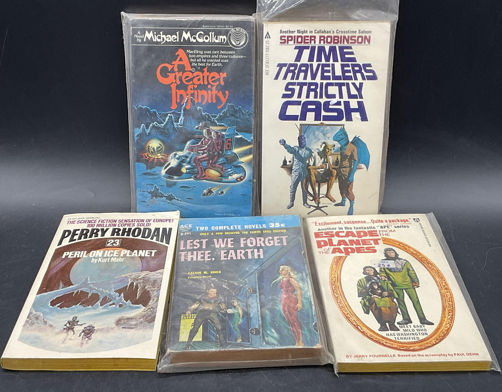 Lot 5 Vintage Science Fiction Books: Five Vintage Science Fiction Books. The lot includes PERIL ON ICE PLANET by Kurt Mahr, C. 1973 Ace Books. Measures approx. 7L x 4.25W in. Four contained in plastic packaging, not examined out of packa