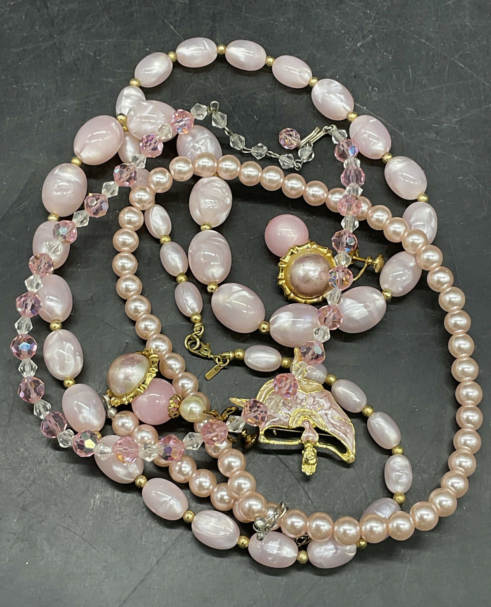 Grp Lot Pink Brooch, Earrings, & Necklaces, Monet+: A group lot of pink hued jewelry which includes earrings, necklaces, and a brooch. Pieces are crafted from metal, crystal, pearlescent beads, and composite materials. Necklace marked MONET on the clas