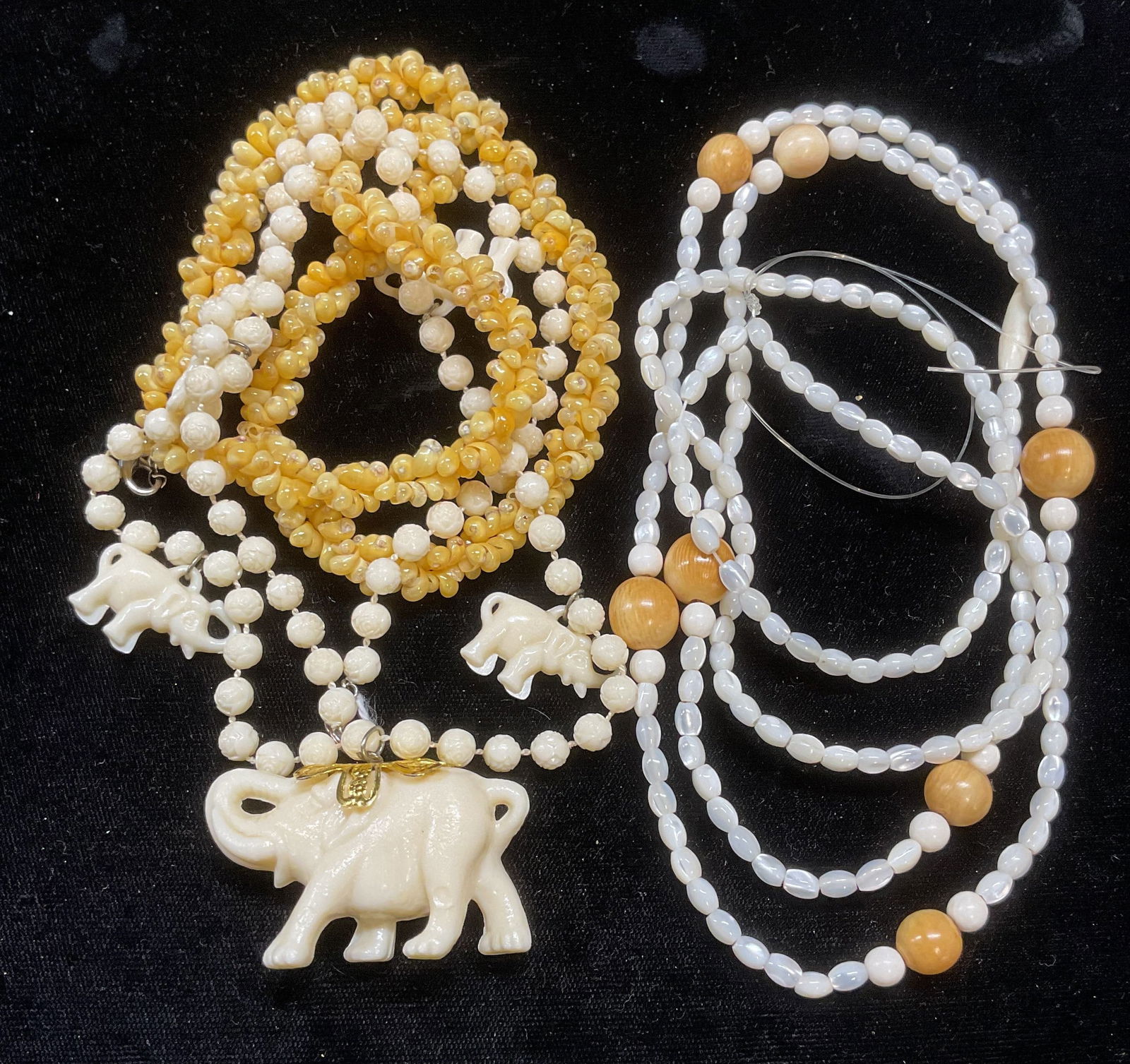 Lot 4 mother of Pearl, Elephant, Shell Necklaces: Lot of 4 vintage necklaces. Mother of pearl and wood beaded necklace, mother of pearl beaded necklace, faux bone acrylic beaded elephant pendant necklace, and shell beaded necklace. Longest drop lengt