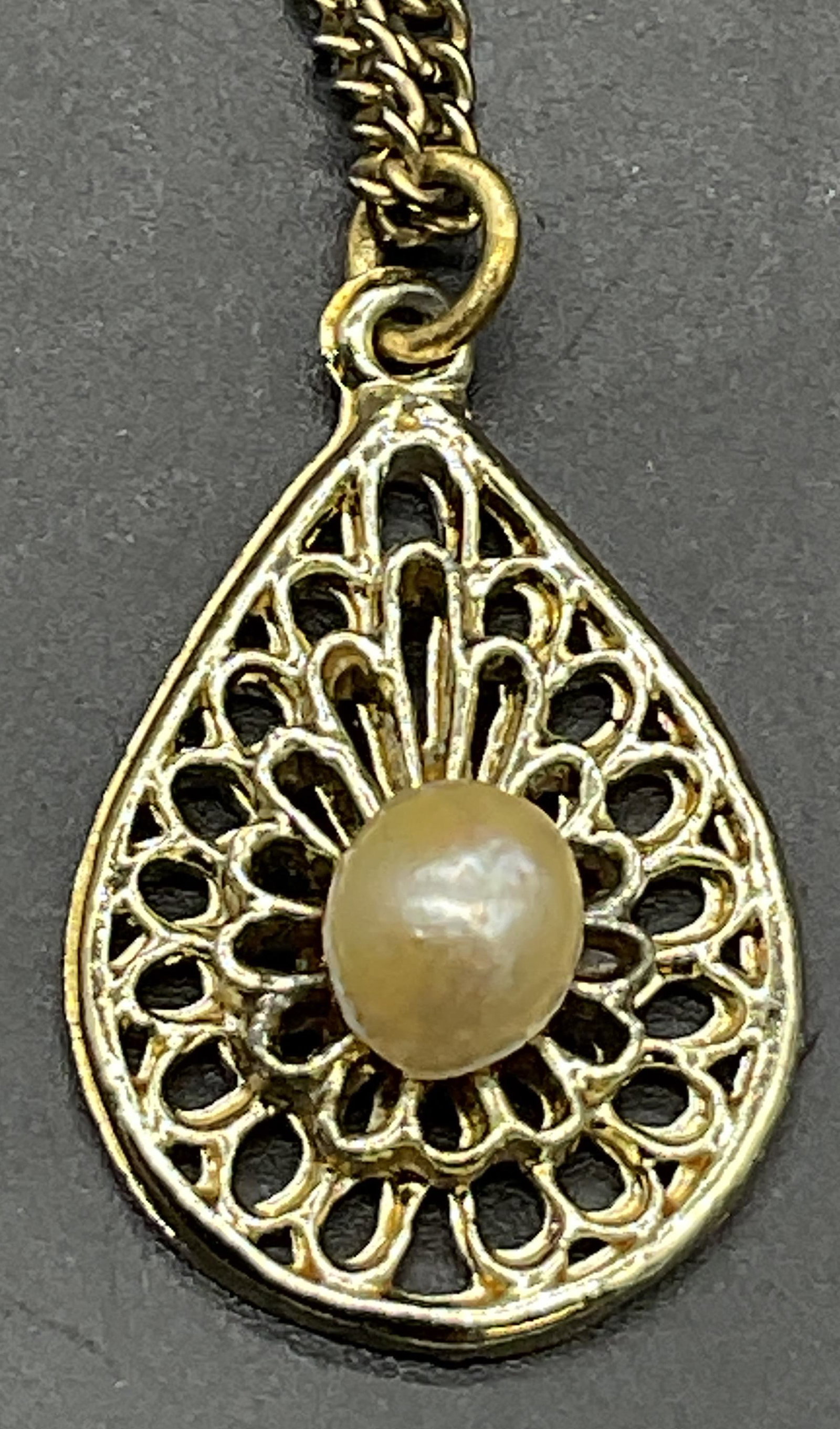 Vintage Metal Filigree Pearl Pendant Necklace: Vintage Filigree Pearl Pendant Necklace. Bezel set Pearl to the center with a drilled hole to the underside of the pearl. Secures with a c-spring clasp closure. Measures approx. 17.5 inches in length,