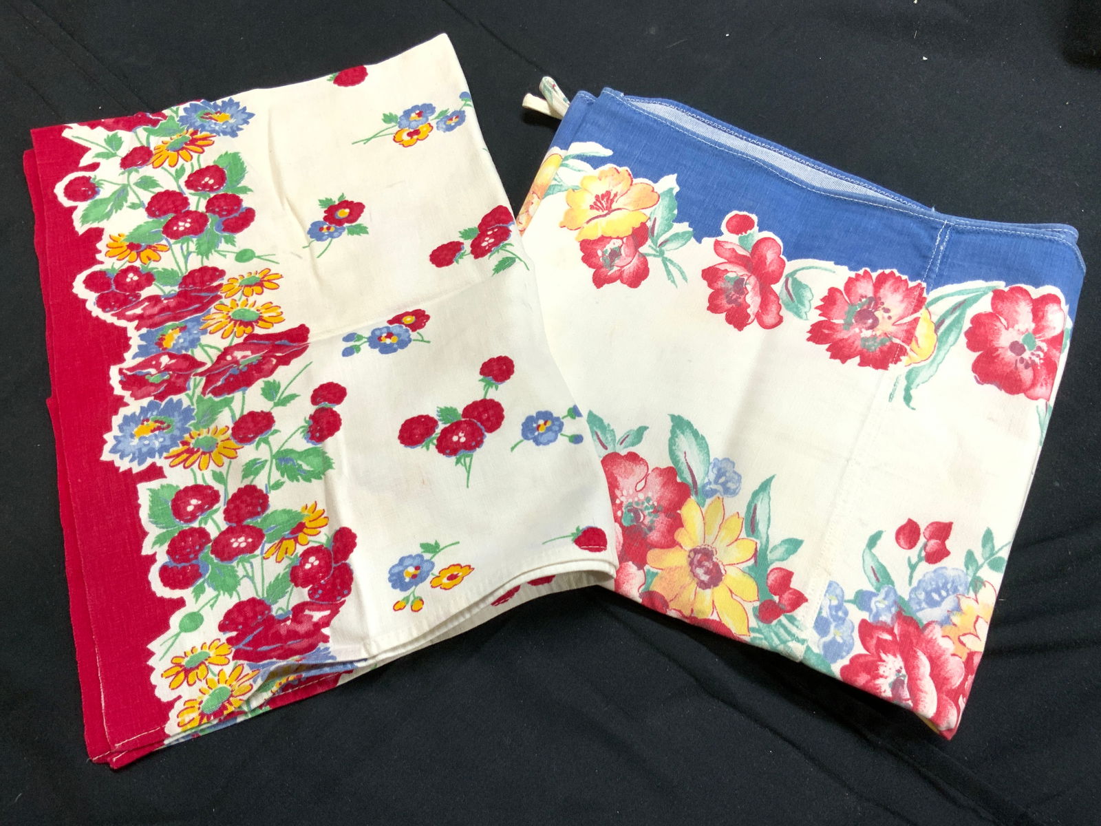 Lot 2 Vtg Floral Detailed Textiles Tbl Linens: Lot includes 2 vintage textiles. Each have intricate multi toned floral and leaf detail. One has red toned edges, the other blue toned edges. Blue edge linen has 2 corners with loops. Larger linen mea