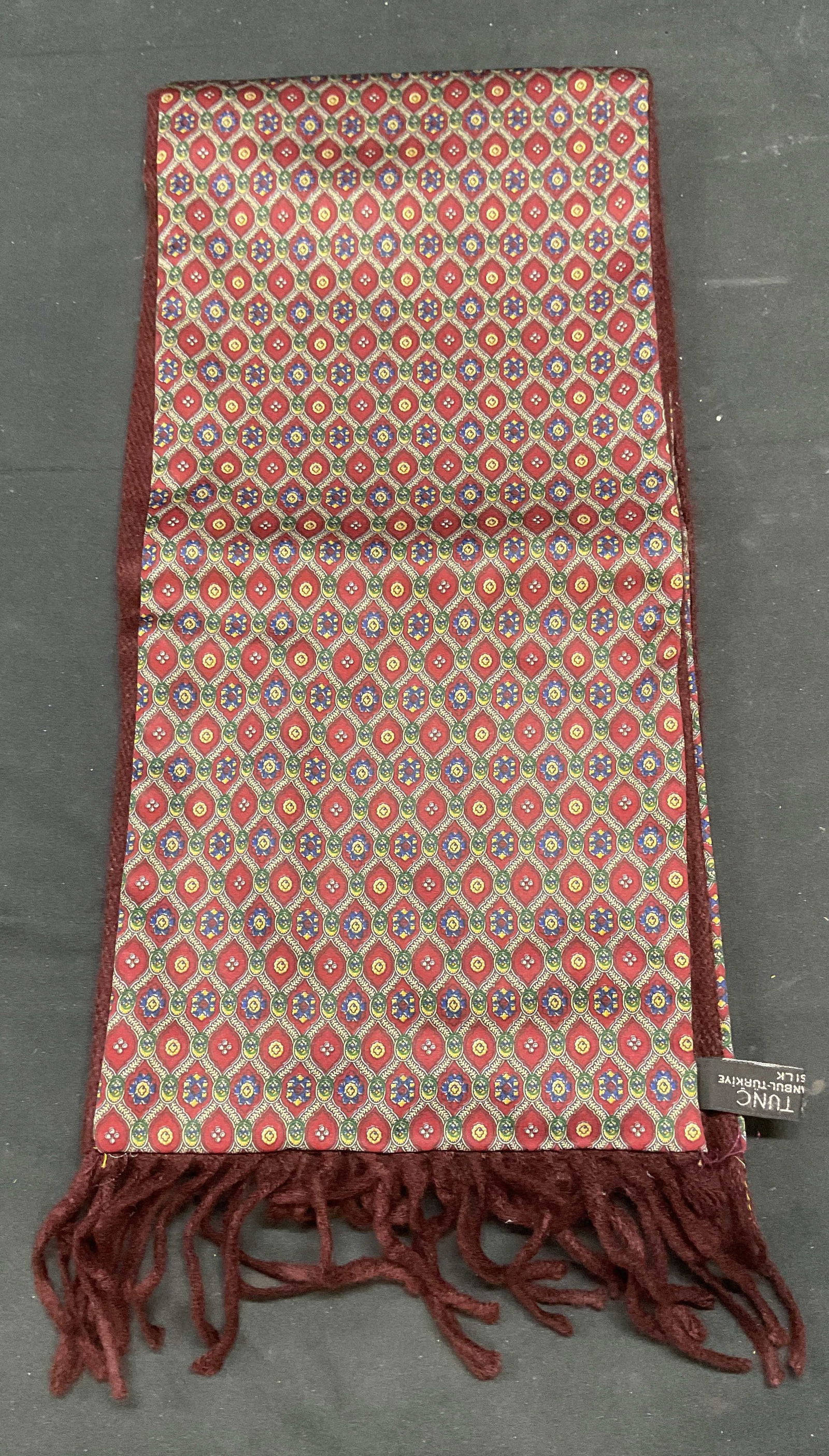 Galeri Tunc Burgundy Print Silk Scarf, Turkey: Galeri Tunc burgundy graphic print silk scarf with fringe. Made in Turkey. Measures approx 66 inches long. Some wear to material consistent with exposure. Galeri Tunc, Galeri Tunc scarf, designer scar