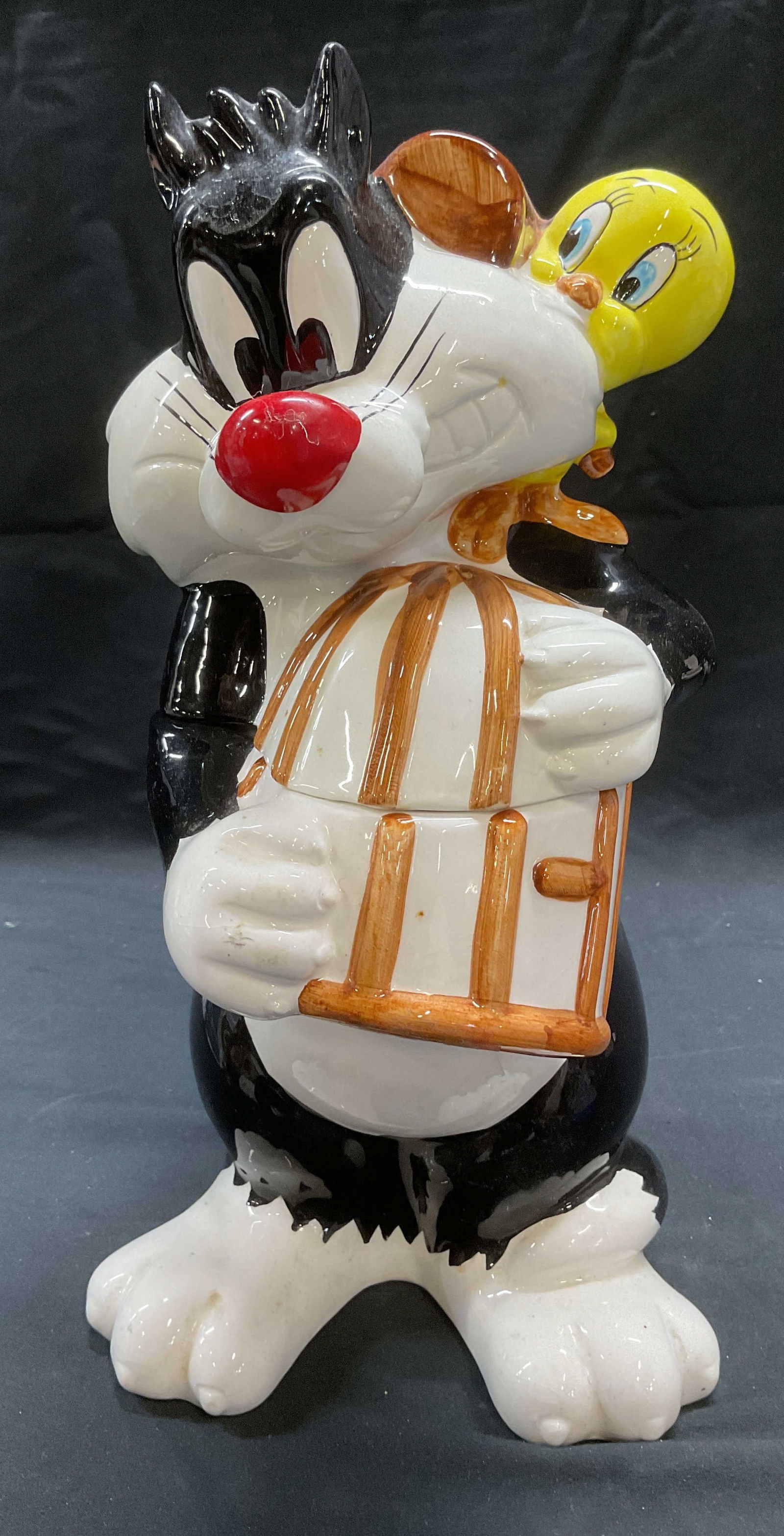1993 Looney Tunes Sylvester Tweety Cookie Jar: 1993 Looney Tunes ceramic cookie jar. Sylvester and Tweety Bird. Signed on undersides. Warner Bros, Certified International Corp. measures approx. 6.75 x 5.75 x 12.75 inches. Wear including residue, s