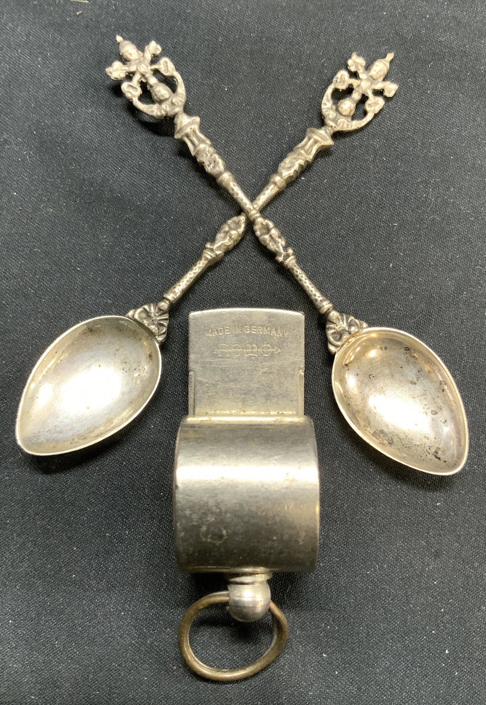 Silver Plate Condiment Spoons & ROMO Whistle: Lot includes 2 condiment spoons. Each are silver plated. Lot also includes 1 metal whistle inscribed ROMO MADE IN GERMANY. Spoons have uniquely formed handles. Each measures approximately 4 inches lon