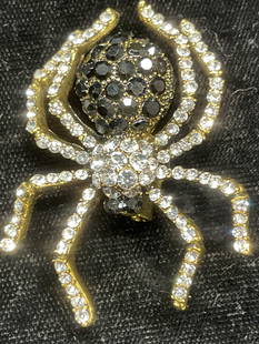 Gold Tone Black Crystal Spider Brooch: Gold tone spider motif brooch with colorless and black crystal decoration. Hinge pin on underside. Measures approx. 2 x 1.5 inches. Some surface wear including scratching observed. Jewelry,