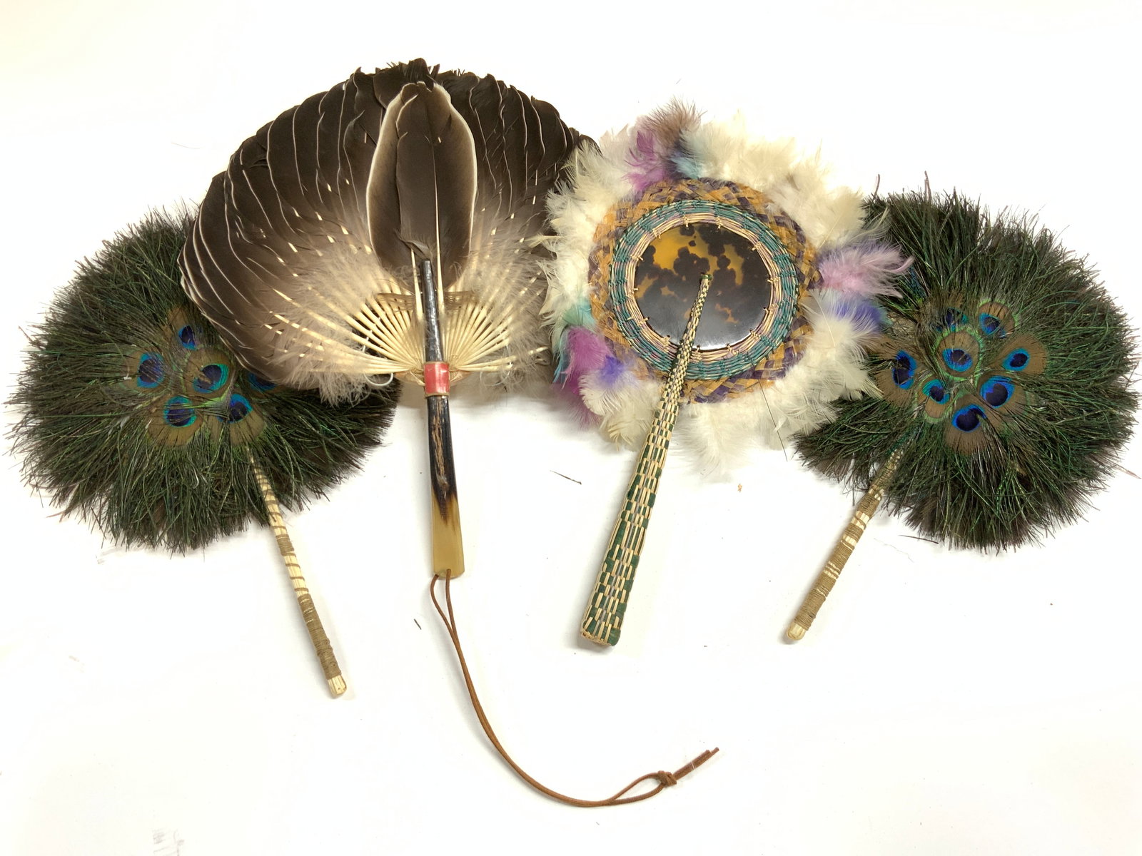 Lot 4 Vintage Feather Handheld Fans: Lot includes 4 handheld fans. Each are crafted from feathers. Each fan appears to be vintage. One handle appears to be bone, 1 handle appears to be woven wicker. Largest hand fan measures approximatel