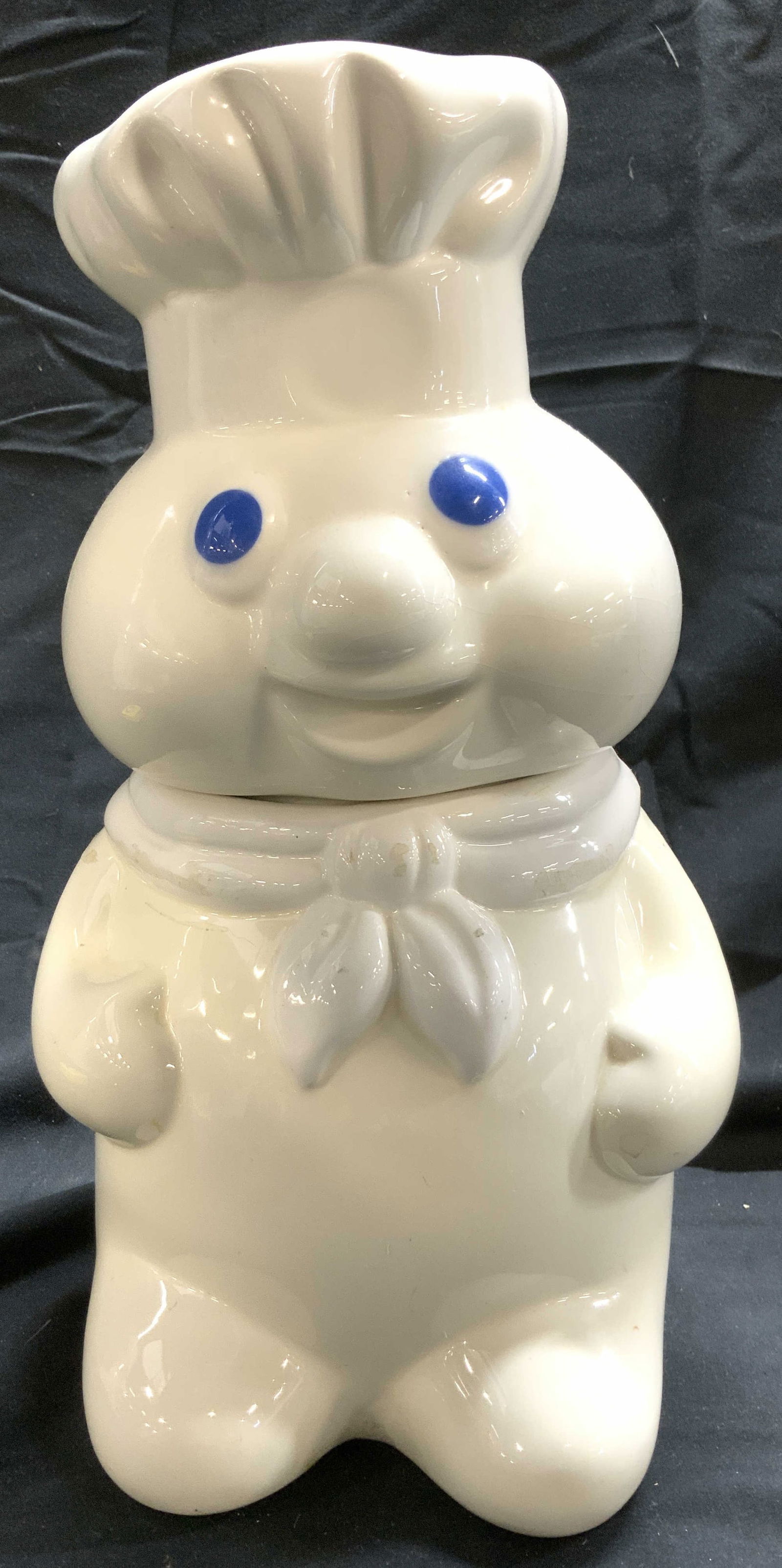 THE PILLSBURY COMPANY Doughboy Porc Cookie Jar: Underside is inscribed THE PILLSBURY COMPANY. Cookie jar is porcelain. Piece depicts PILLSBURY doughboy. Cookie jar is white and blue toned. Piece Measures approximately 12 inches tall 6.5 inches wide
