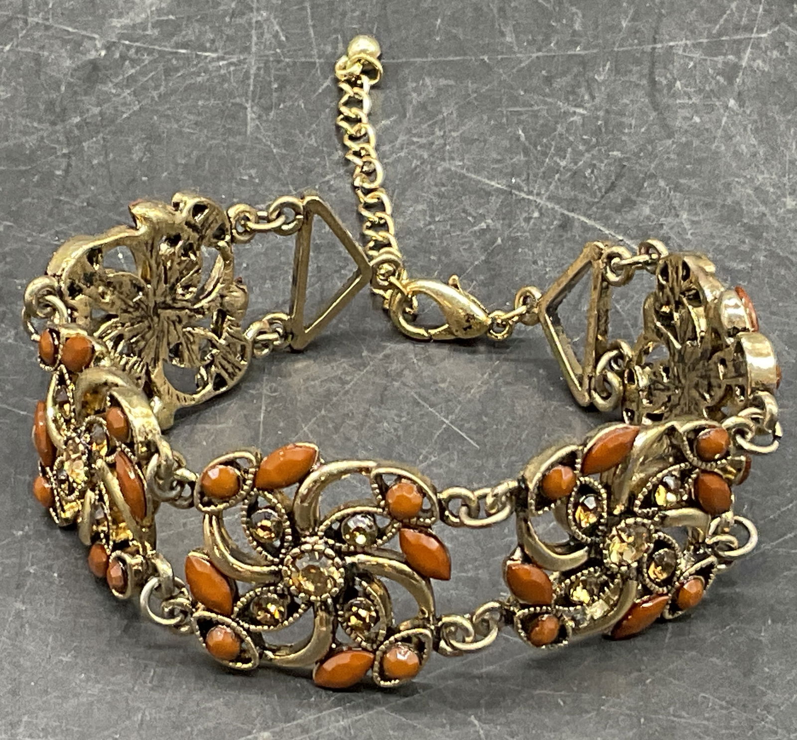 Vintage Bejeweled Crystal Bracelet: Vintage Bejeweled Crystal Bracelet. Gold tone metal bracelet with brown and amber hued crystals throughout. Lobster claw clasp closure. Length measured end to end approx. 9 inches. Surface wear consis