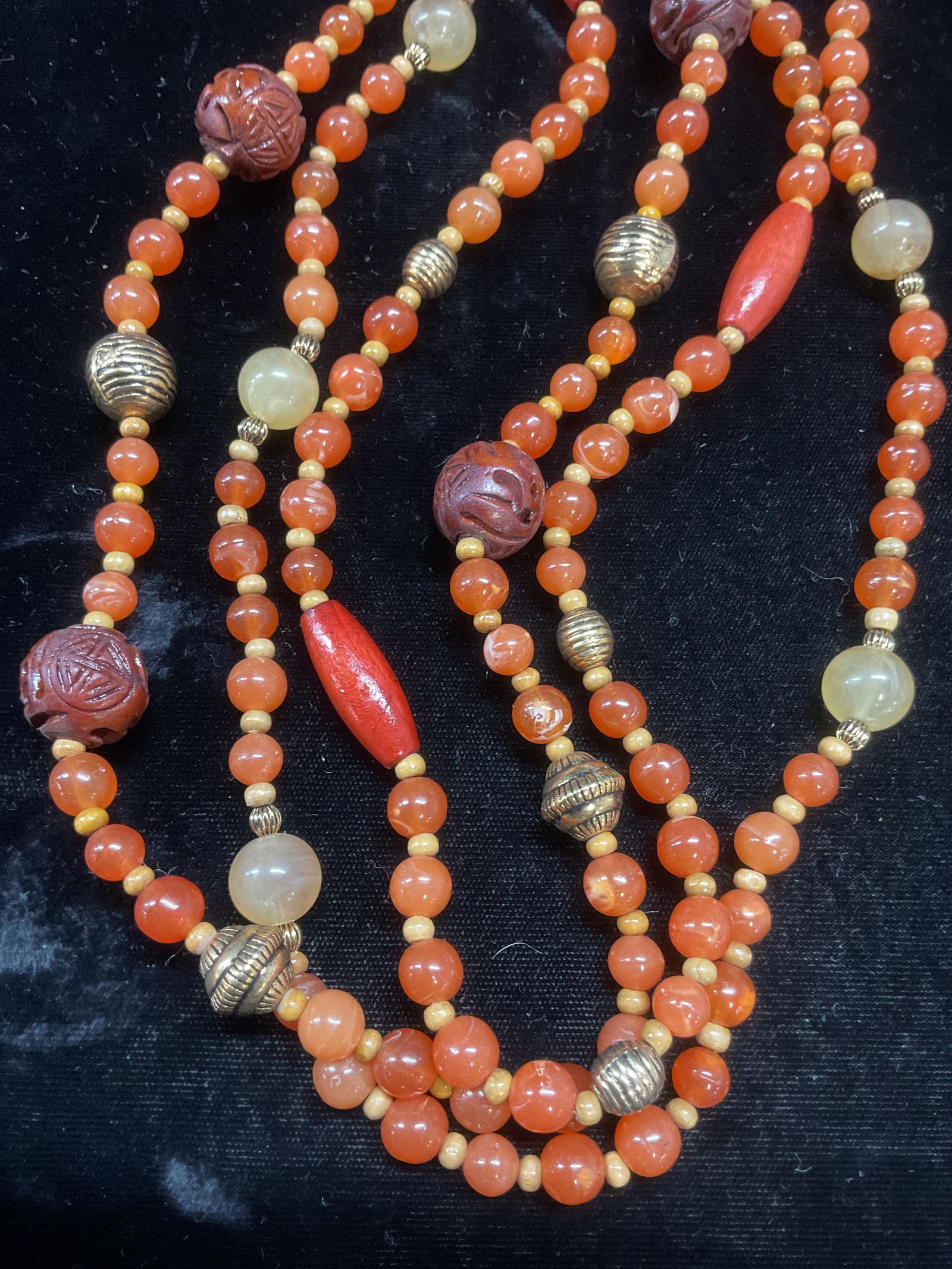Vintage Avon Faux Carnelian Beaded Necklace: Vintage Avon faux carnelian, gold tone, and Asian motif beaded multi strand necklace. Signed on hang tag. Drop length approx 14.5 inches. Some wear including scratching observed. Jewelry, estate jewel