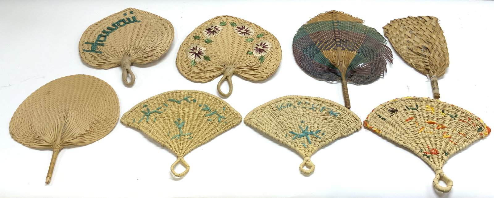 Lot 8 Assorted Woven Wicker & Rattan Hand Fans: Lot includes 8 handheld fans. Some woven wicker some woven rattan. Most pieces are tan toned. One reads Hawaii. St Thomas, Nassau. One has floral and leaf detail. One fan is teal, purple and navy tone