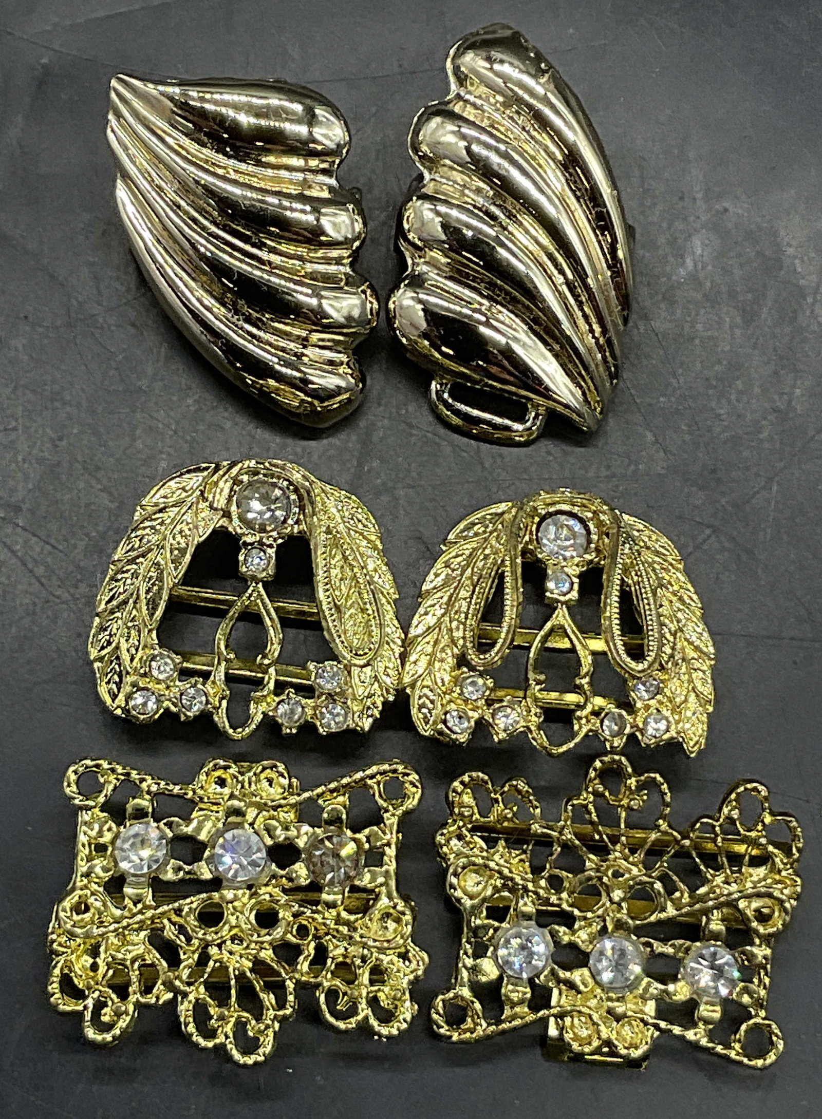 Lot 3 Vintage Gold Tone Metal Belt Buckles: Lot 3 Vintage Gold Tone Metal Geometric Belt Buckles. Pieces are crafted from gold tone metal. Some pieces feature faceted crystals. Single polished gold tone belt buckle piece measures approx. 1.75L 