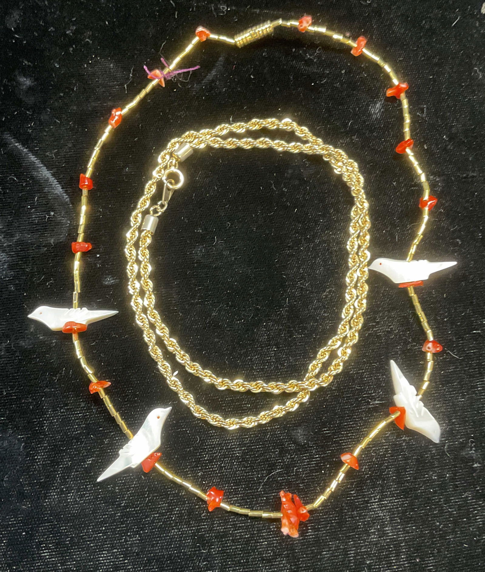 Lot 2 Gold Tn Coral Mother of Pearl Necklace +: Lot of 2 gold tone necklaces. Coral and carved bird mother of pearl beaded necklace. Twisted rope chain necklace. Longer drop length approx 9.5 inches. Wear to each including scratching observed. Jewe