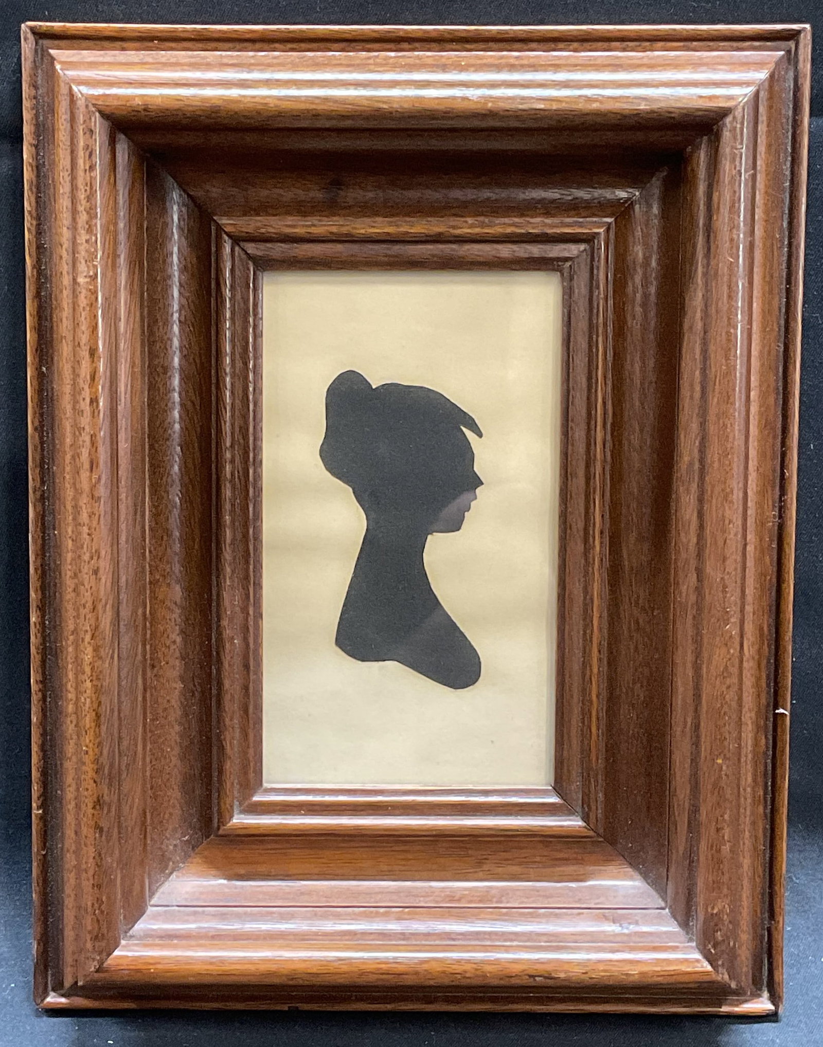 Framed Folk Art Cut Out Silhouette, Woman: Framed folk art silhouette. Black paper cutout on white paper. Bust of a woman. Framed in wood frame. Not examined out frame. Frame measures approx 8 x 6 inches. Some wear consistent with exposure. Ar