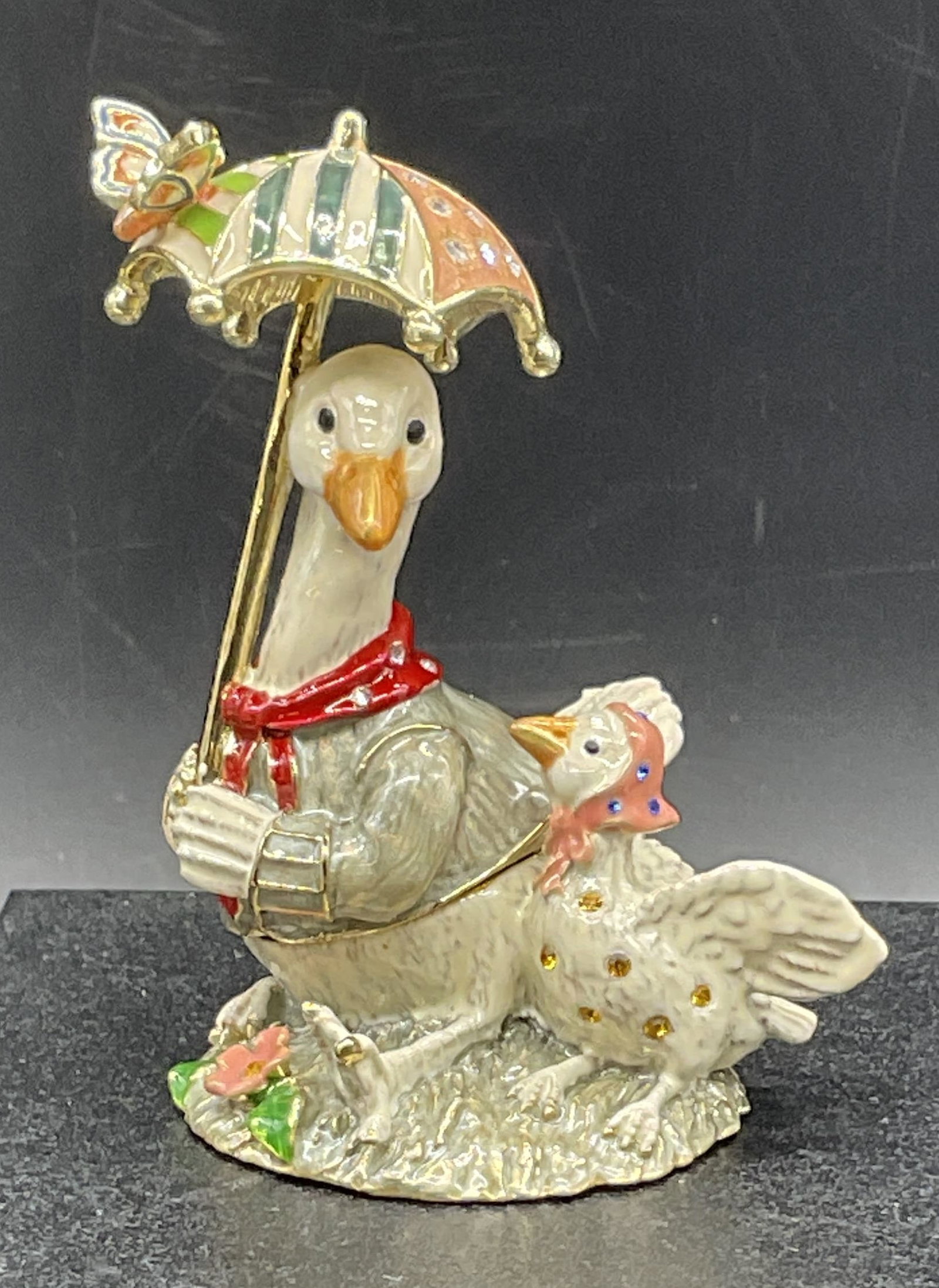 KEREN KOPAL Enamel Geese Trinket Box, Bx: Keren Kopal Enamel Geese Trinket Box contained in black box. Crystal decoration to the piece. Two geese are depicted, one holds an umbrella. Signed on interior. Box Measures approx. 3.25H x 4.5W in. B