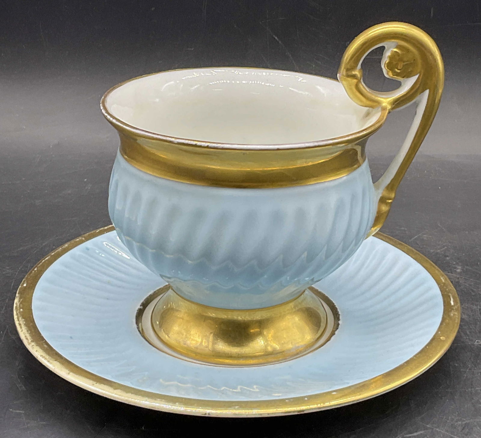 LIMOGES FRANCE Blue & Gilt Porc Tea Cup & Saucer: LIMOGES FRANCE Blue & Gilt Porcelain Tea Cup & Saucer Set. Undersides read LIMOGES FRANCE. Tea cup measures approx. 5H x 5W in. Losses to finish, pitting, surface wear, an$ discoloration present. home