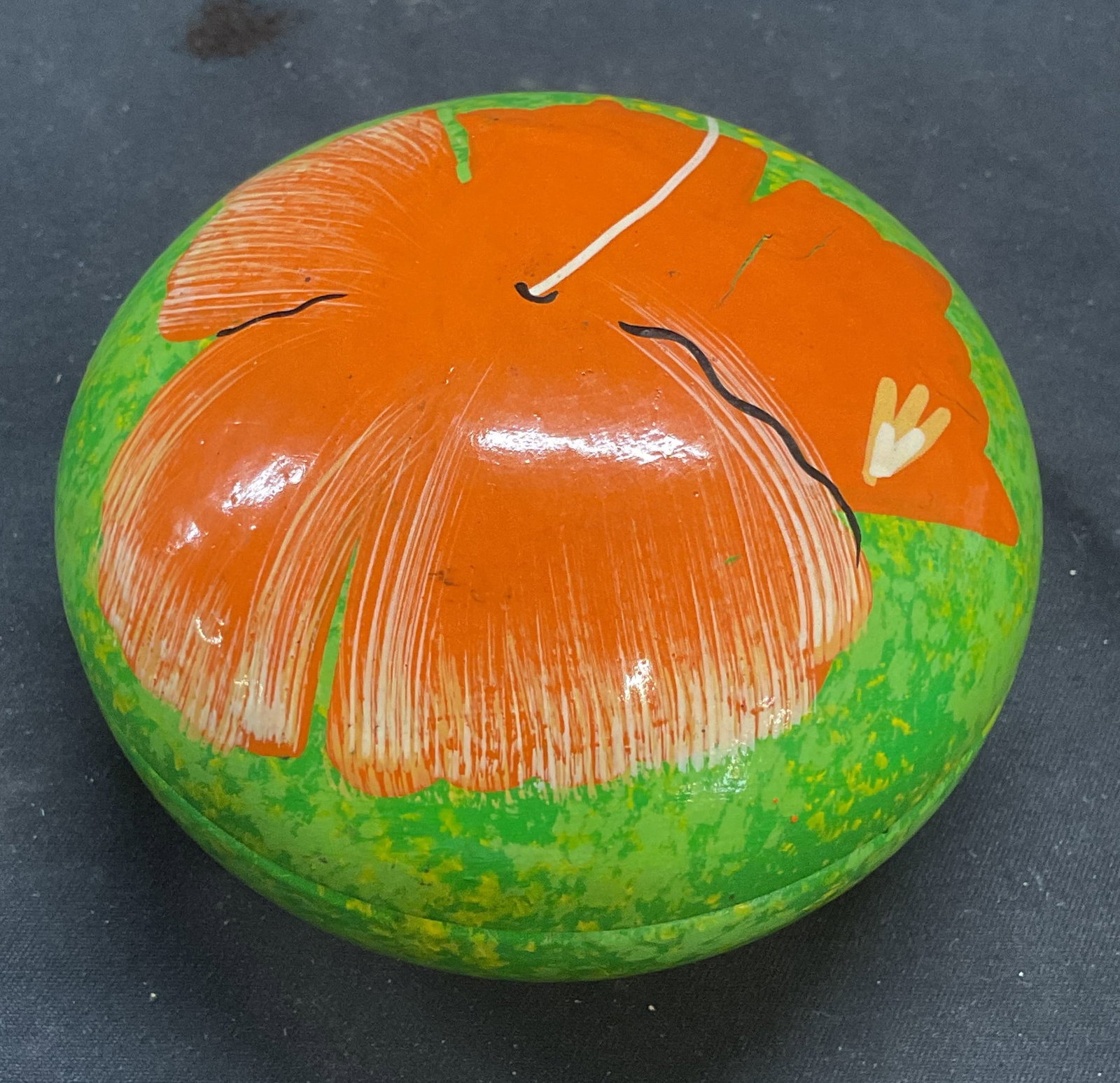 Hand Painted Wood Hibiscus Flower Trinket Box: Hand painted wood hibiscus flower trinket box. Round shaped. Green and orange. Marked St Lucia. Measures approx 3 3/8 x 2 inches. Some wear including scratching and loss to paint observed. Trinket box