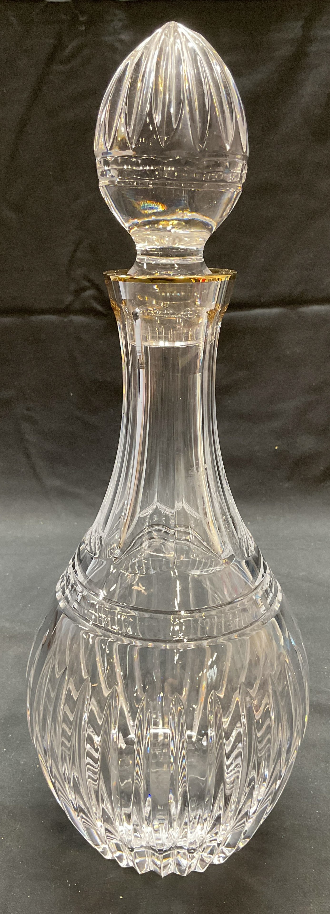 Marquis by Waterford Gilt Crystal Decanter: Marquis by Waterford cut crystal decanter with gilt rim and stopper. Rounded shape with ribbed and faceted design. Signed on underside. Measures approx. 4.5 x 9.25 inches excluding stopper. Thick wall