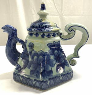 Vintage Asian Stoneware Teapot W Lid: Teapot is vintage. Piece appears to be stoneware, possibly heavy weight porcelain. Teapot includes lid. Piece has blue toned floral and leaf detail. Teapot has uniquely formed handle & phoenix