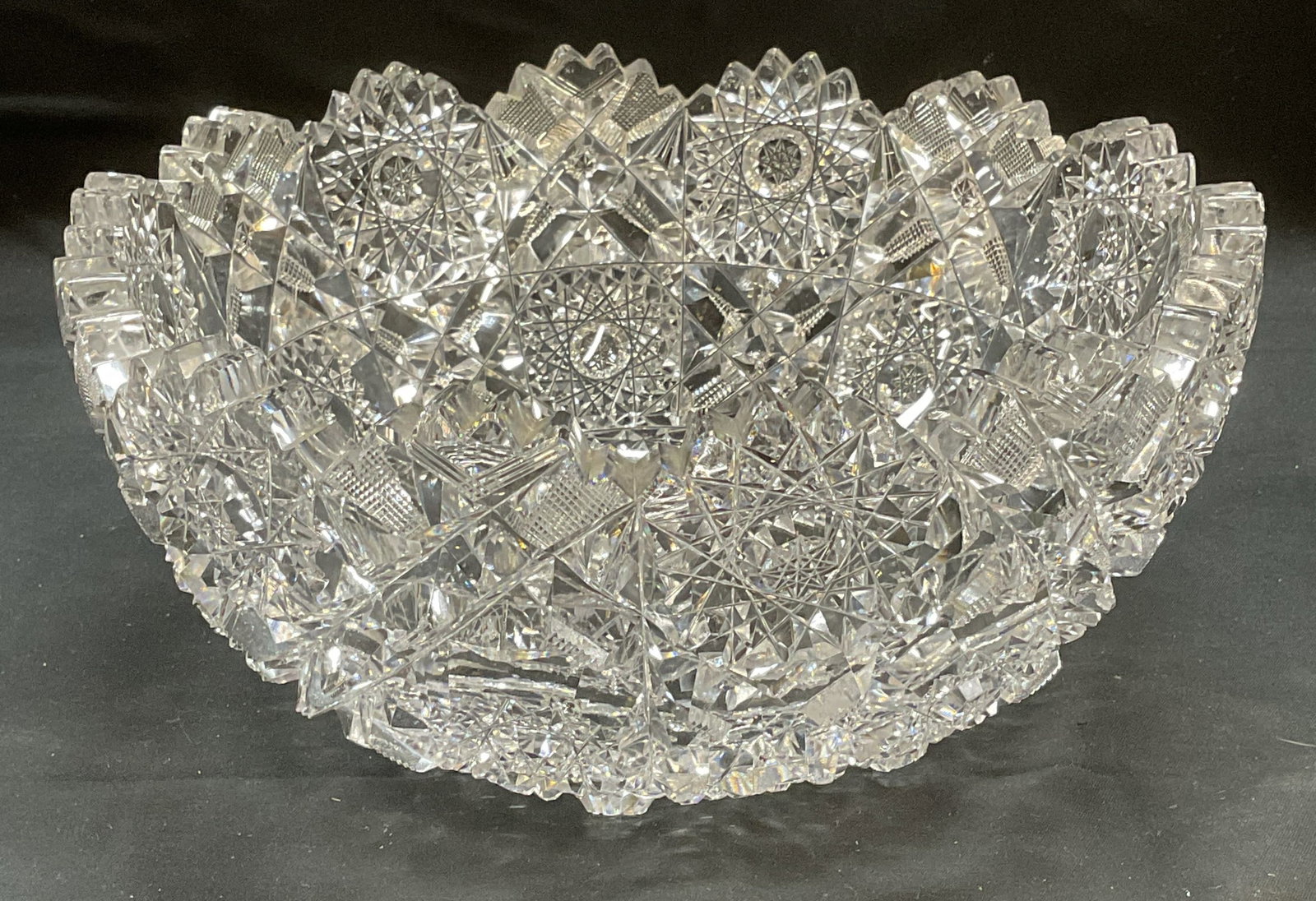 Antique ABP Hand Cut Glass Hobstar Bowl: Antique American Brilliant Period hand cut glass bowl. Sawtooth rim with hobstar, strawberry diamond, and trellis pattern. Some wear including scratching observed. Measures approx 9 in in diameter by 