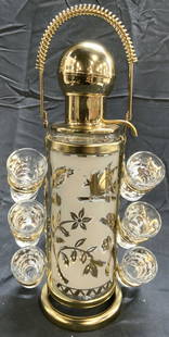GLEN SHAW GLASSWORKS MCM Decanter W Shot Glasses: Set appears to be GLEN SHAW GLASSWORKS. Set includes 1 decanter & 6 shot glasses. Set has gilt metal rack with coil handle and circular base. Set is mid century modern. Each piece has frosted and gilt