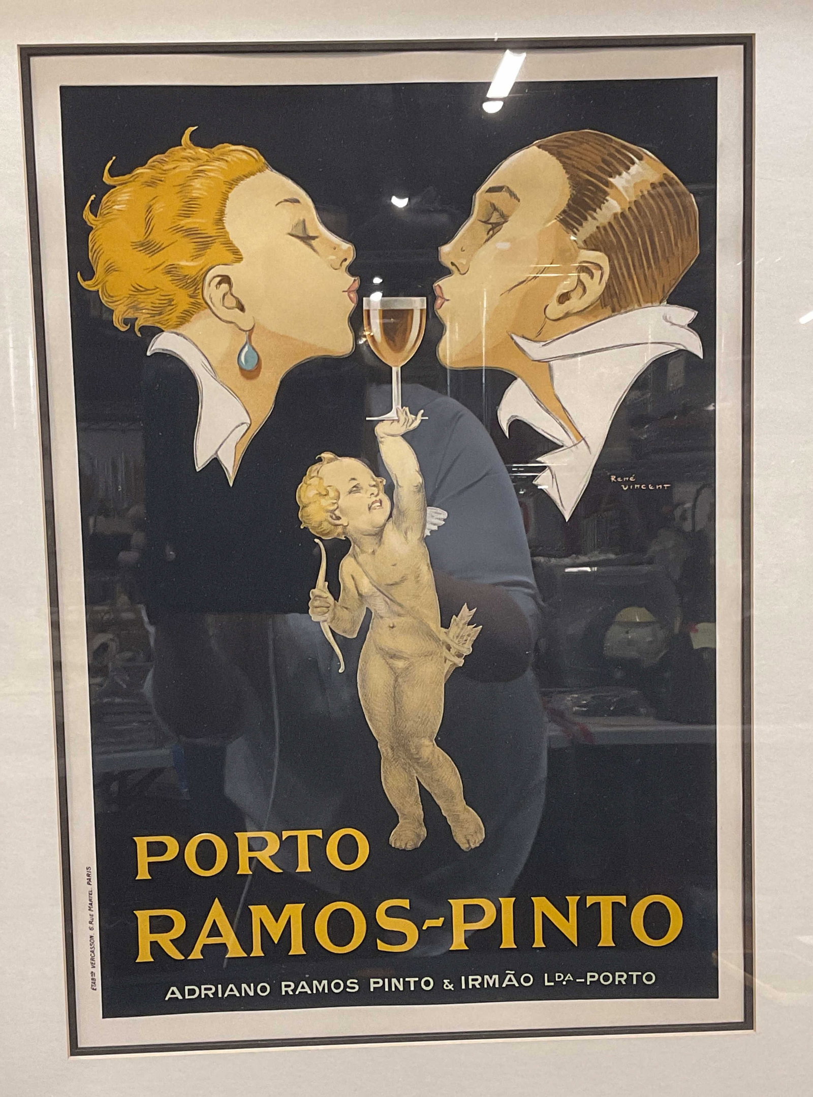 Rene Vincent Porto Ramos PintoWine Advert Litho Fr: Framed and matted lithograph print. Artwork by Rene Vincent, signature in print at center right. Porto Ramos Pinto wine advertising print. Two figures and Cupid figure holding up wine glass. Publisher