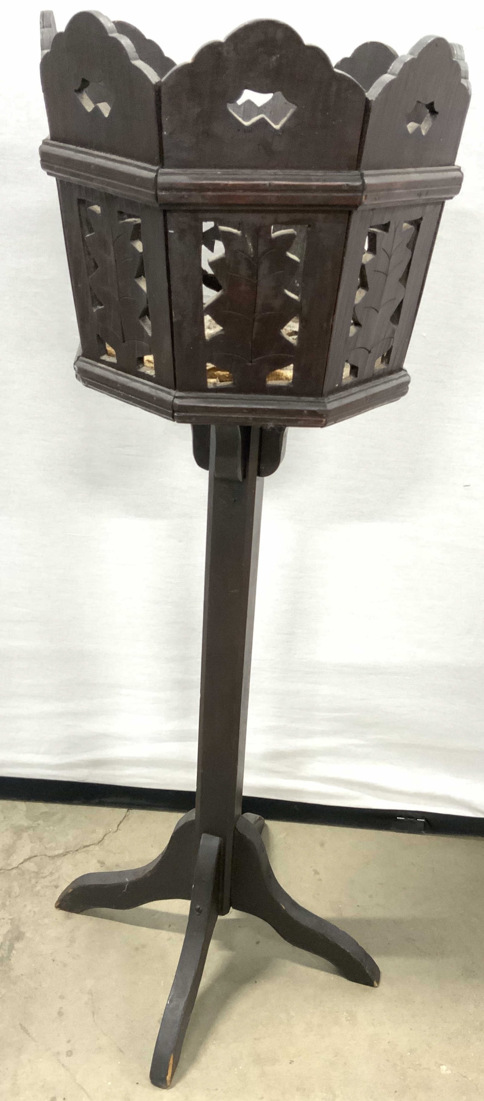 Vintage Carved Wooden Planter Stand: Planter stand is dark chocolate toned & wooden. Piece is vintage. Top of stand has leaf structures & pierced detail. Base has quad pod support. Plant stand measures approximately 32 inches tall 10.25 