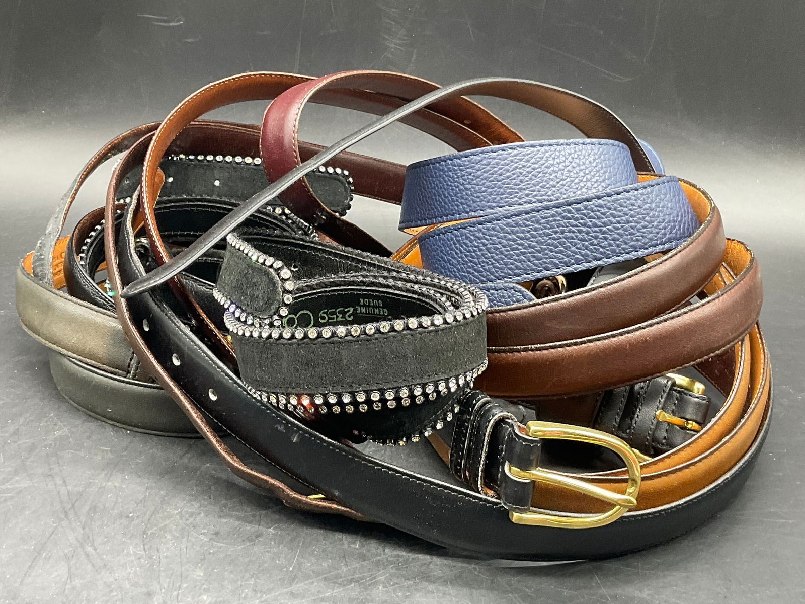 Group Lot Leather & Leatherette Belts, Coach +: Group Lot 11 Leather & Leatherette Belts. Brands include COACH, COURAGE B, and more. Primarily black, brown, or blue hues. The belt buckles are primarily suede style fabric, silver tone metal, or gold