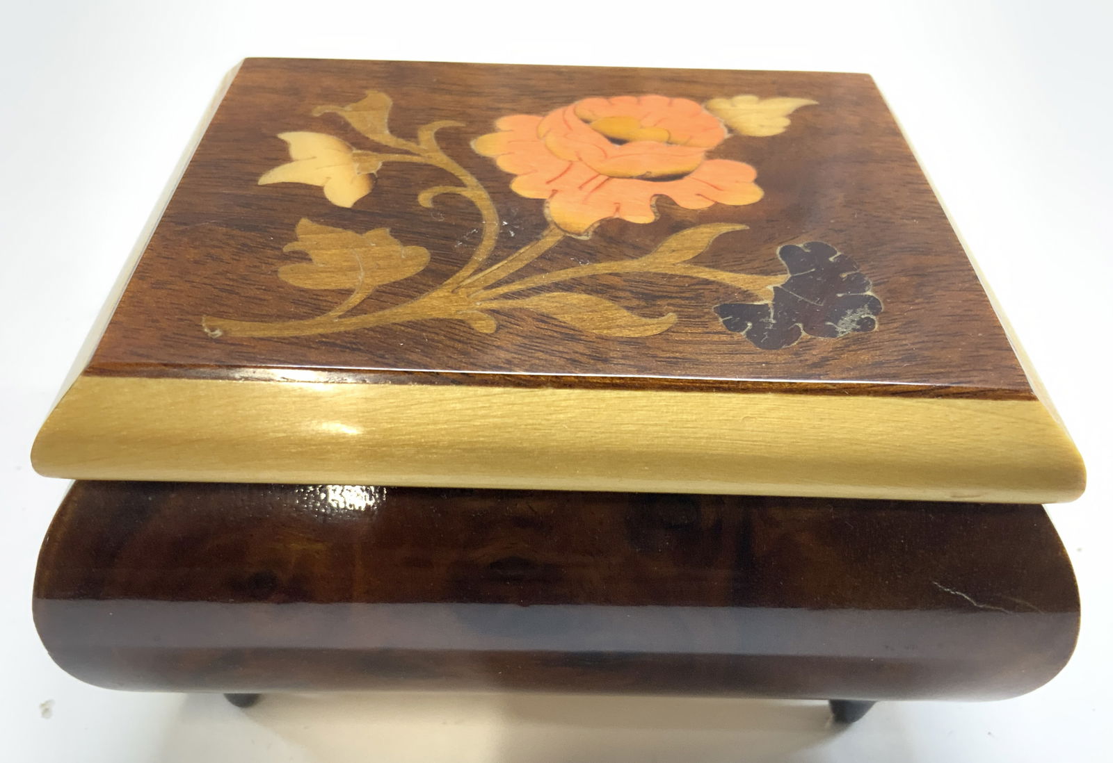NARCO Vntg Inlaid Wooden Music Box W Feet: Interior movement is inscribed NARCO JAPAN. Music box is wood with inlaid floral, vine and leaf detail. Music box is footed with 4 black toned feet. Music box has hinged lid. Piece measures approximat
