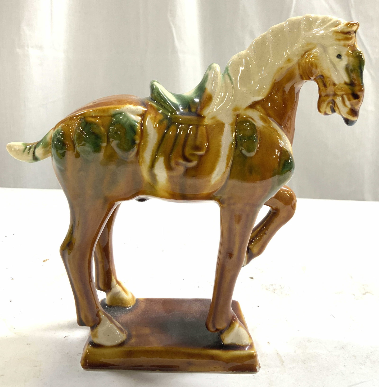 Antq Chinese Tang Dynasty Ceramic War Horse Figure: War horse figure appears to be antique, possibly vintage. Piece is ceramic. Horse figure has amber, cream and green tones. Piece measures approx 7 inches tall 6 inches deep 2.25 inches wide. War horse