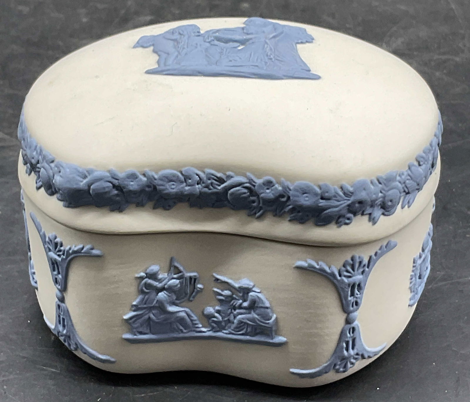 WEDGWOOD ENGLAND Jasperware Trinket Box, Lid: WEDGWOOD ENGLAND Blue and White Jasperware Trinket Box. Lidded. Raised Greco Roman motifs throughout the base and lid. Underside is signed, worn, appears to reads WEDGWOOD ENGLAND. Measures approx. 2H