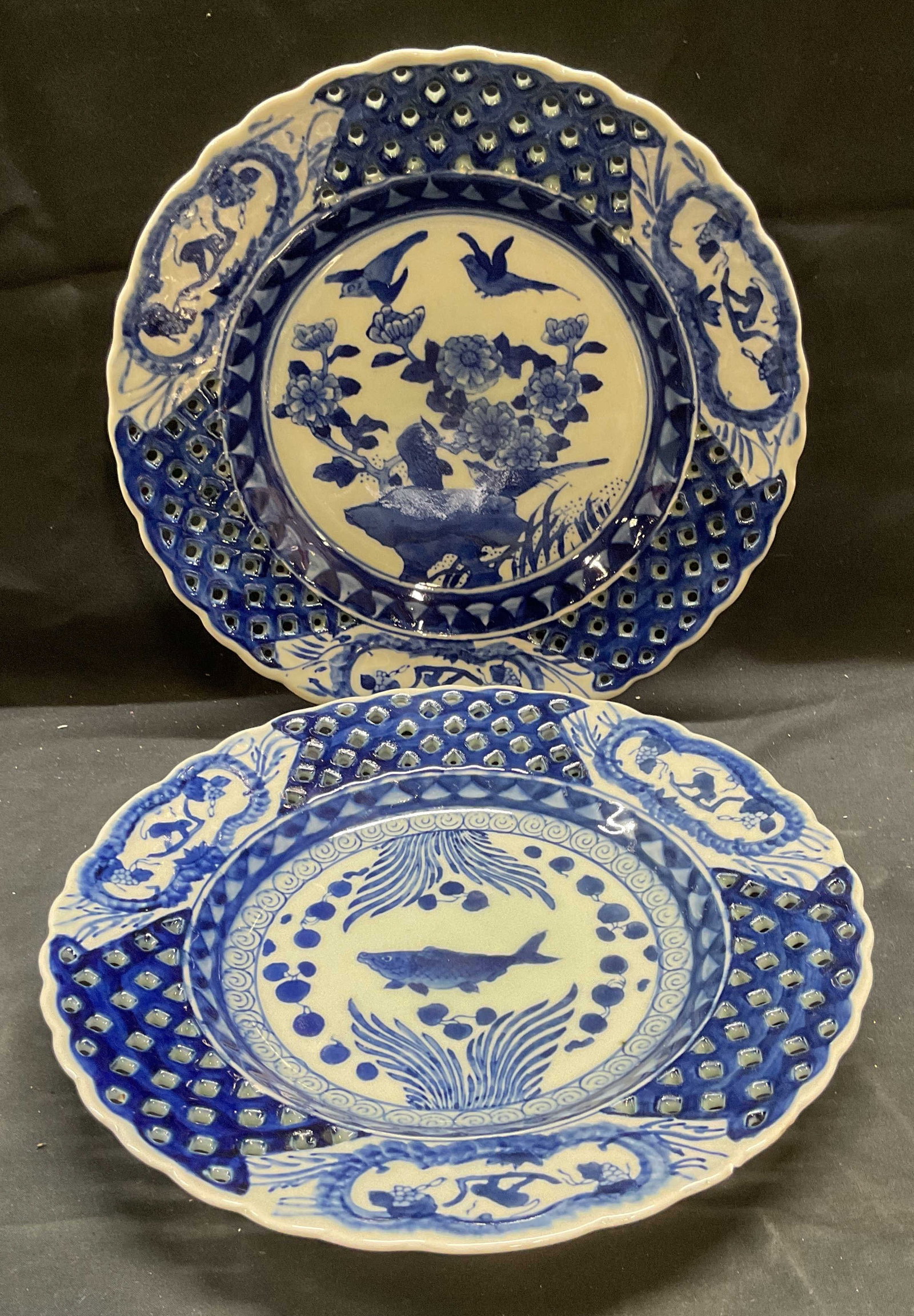 Lot 2 Signed Asian Porcelain Blue & White Plates: Lot of 2 signed Asian porcelain plates in blue ands white. Signed on undersides. Reticulated rims and scalloped edges. One plate with fish motif and one plate with floral motif. Hand painted decoratio
