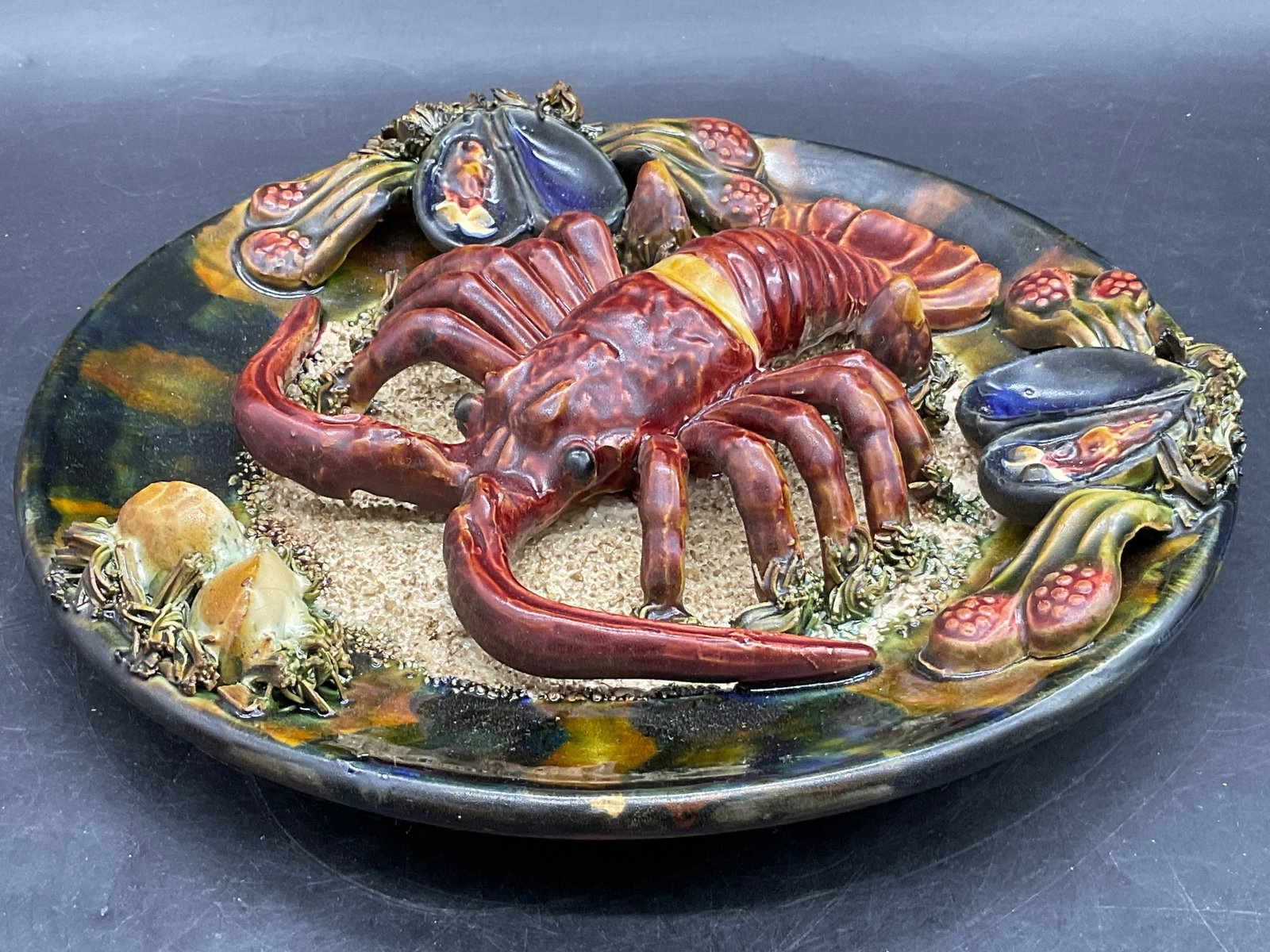 ANTHROPOLOGY PORTUGAL Majolica Lobster Dish: ANTHROPOLOGY PORTUGAL Majolica Pottery Lobster Dish. Raised seafood and foliage throughout the obverse. Thick walled and weighty. Stickers to the underside read ANTHROPOLOGY, MADE IN PORTUGAL. Drilled