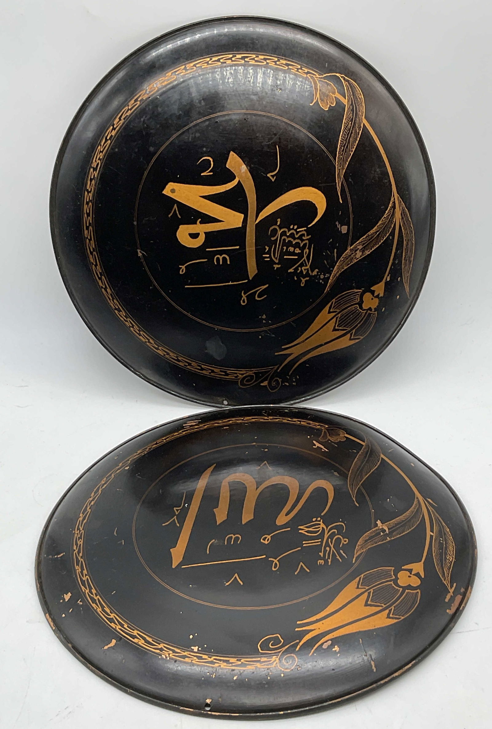 2 Stylized Calligraphy Painted Black Copper Plates: Two Stylized Calligraphy Painted Black Copper Plates. The obverses feature Hand painted florals, stylized calligraphy, and geometric patterns. Copper reverse. Drilled holes to pieces. Similar in size,