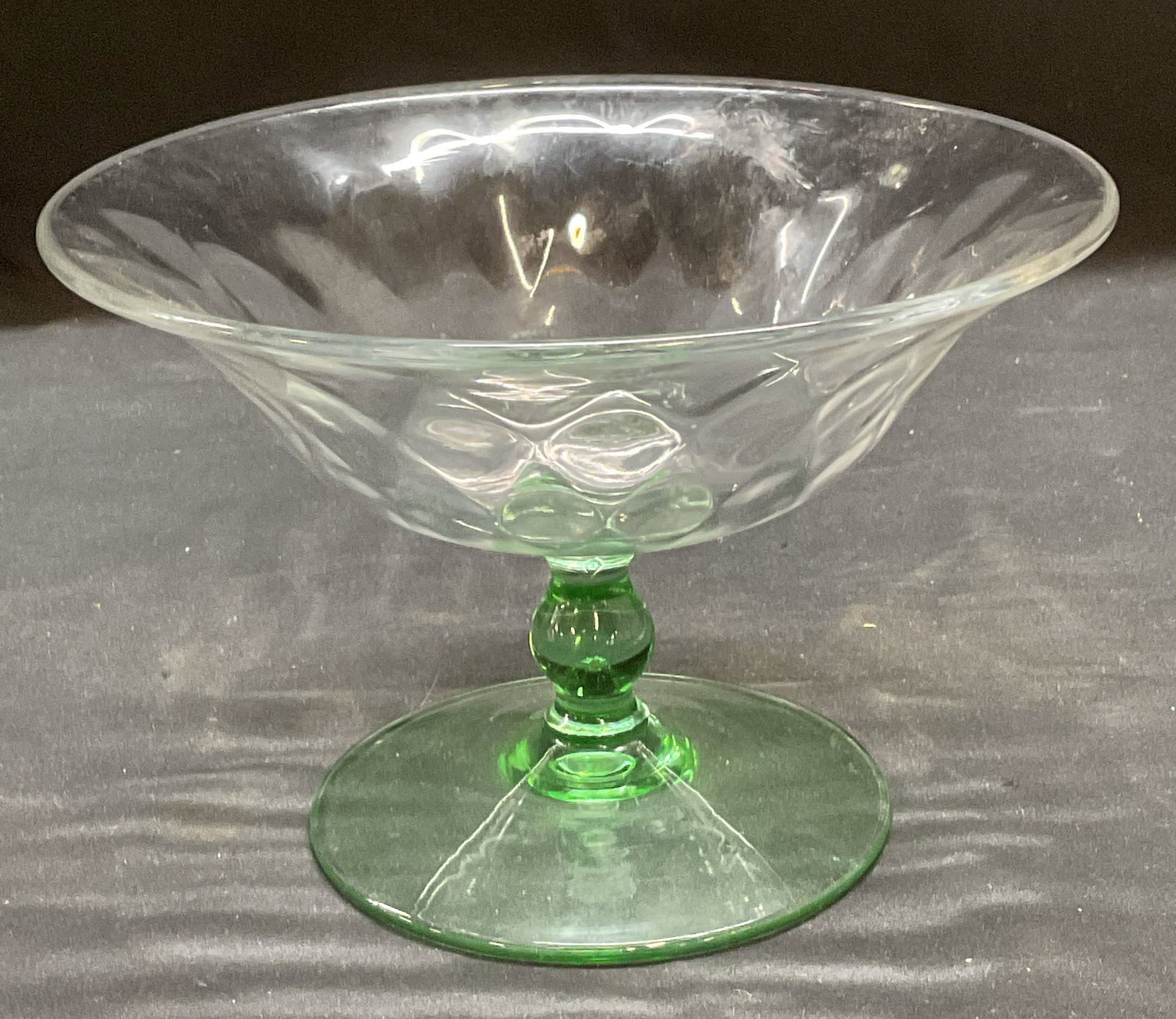 Vintage Clear/Green Uranium Footed Glass Bowl: Vintage uranium depression glass footed bowl. Clear bowl with green stem and base. Fluoresces under UV light. Measures approx 6.5 x 4.5 inches. Some wear including scratching observed. Uranium glass, 