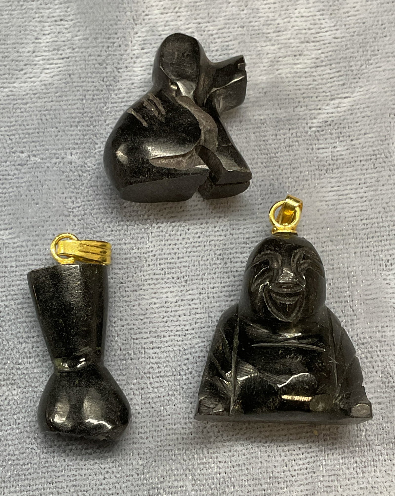 Lot 3 Vtg Black Stone Buddha, Dog, Hand Pendants: Lot of 3 Vintage carved black stone pendants. Hand fist motif, dog motif, and Buddha motif. Largest approx 7/8 x .75 inches. Some wear to all including scratching observed. Jewelry, estate jewelry, co