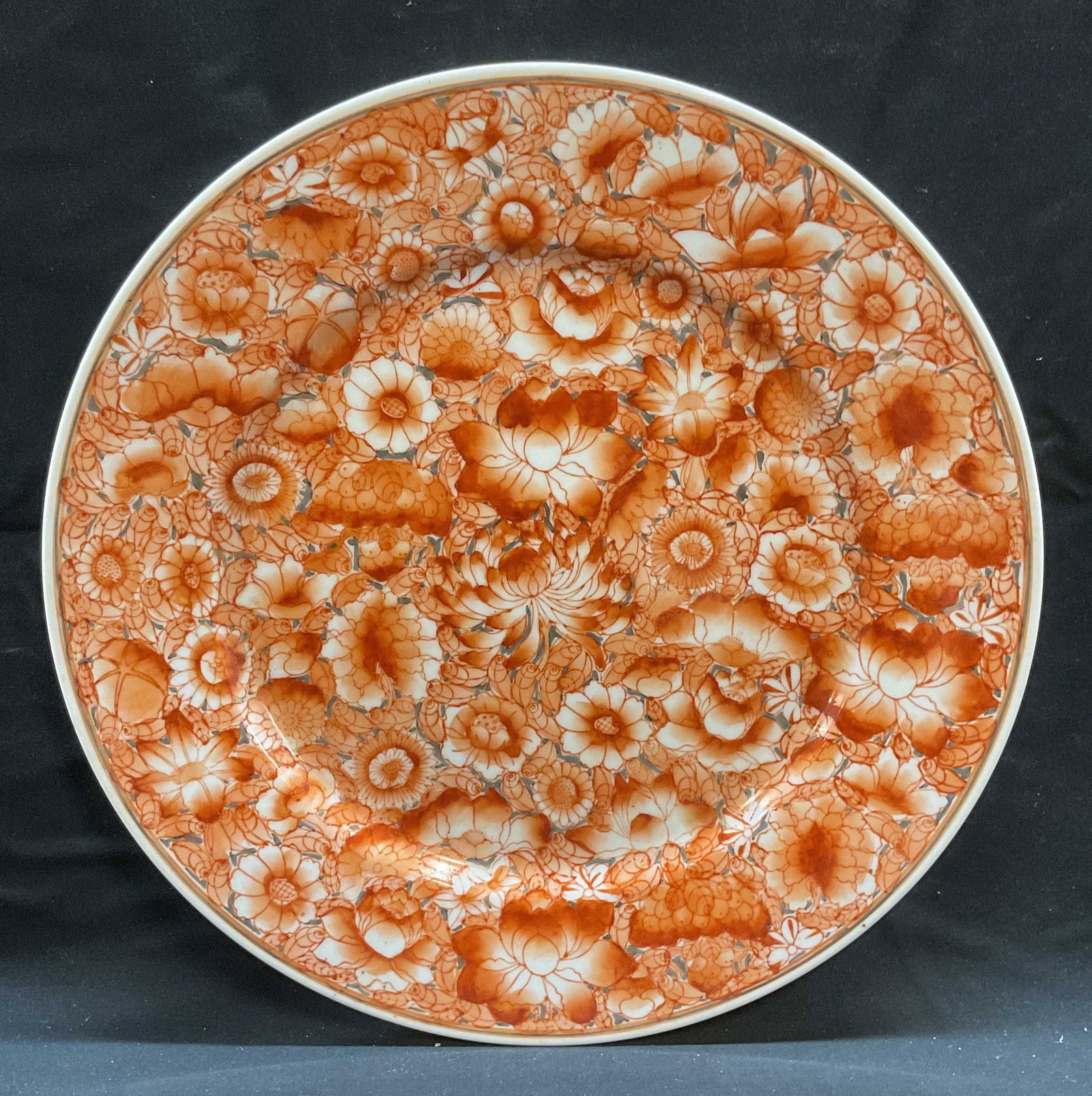 Asian Porcelain Red Floral Charger Plate: Asian porcelain charger plate. Hand painted in red with floral design. Measures approx 12 inches wide. Some wear including loss to paint and scratching observed. Porcelain charger, charger, display pl