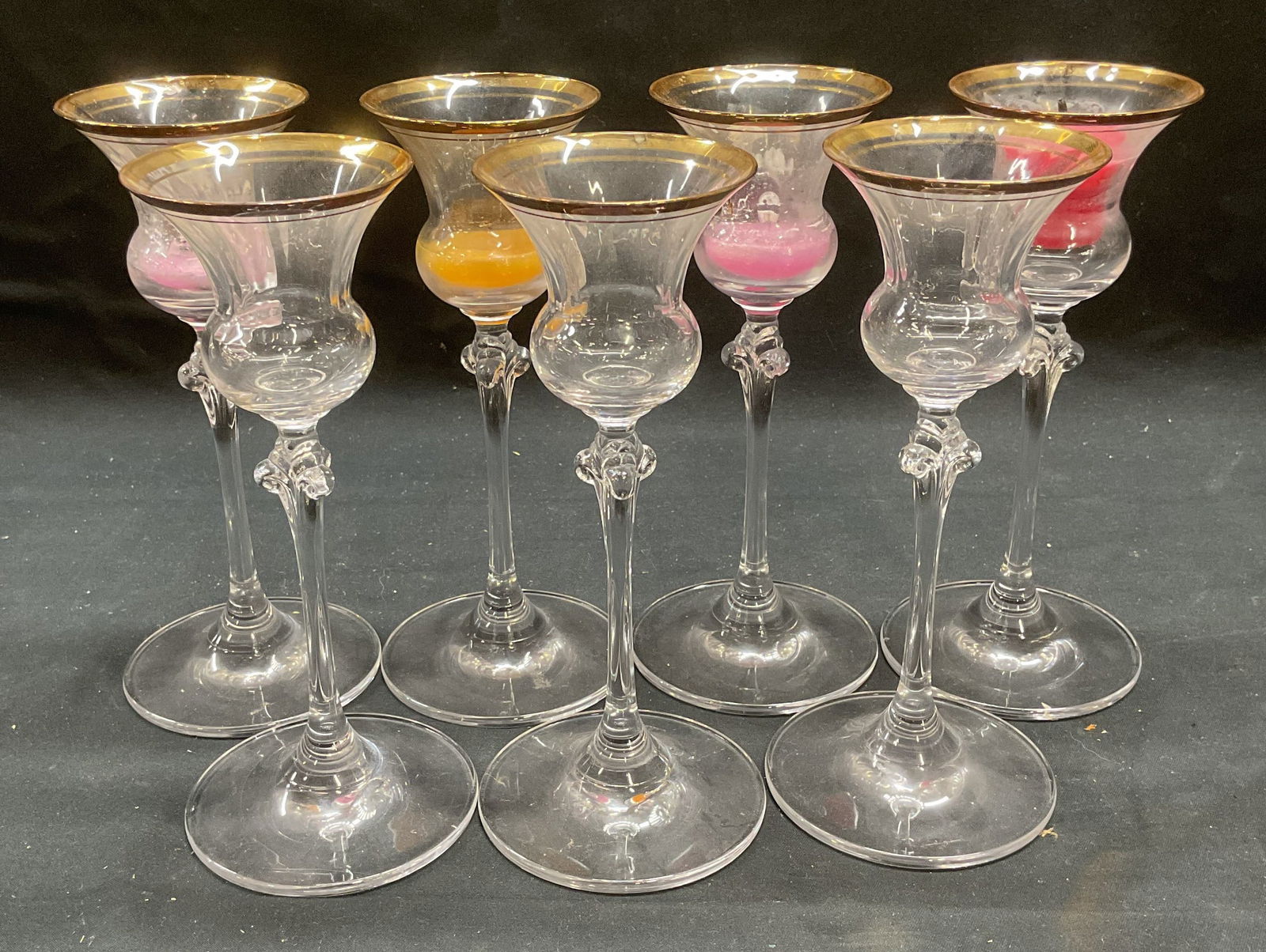 Set 7 Gilt Glass Candle Holders: Set of 7 glass candle holders with gilt rims. Long stem with wide base. Measure approx 2.75 x 6.25 inches each. All pieces have wear including scratching and residue. Candle holder, glass candle holde