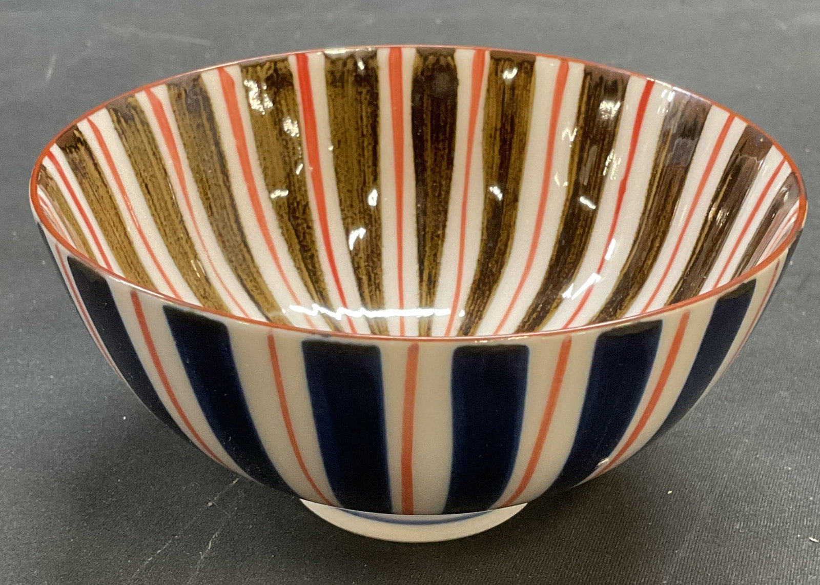 Sgn Asian Mino Ware Tokusa Porcelain Rice Bowl: Signed Asian porcelain rice bowl. Mino ware Tokusa style. Striped pattern in red, white, and blue. Signed on underside. Measures approx 4.5 x 2.25 inches. Some wear consistent with exposure. Tokusa bo