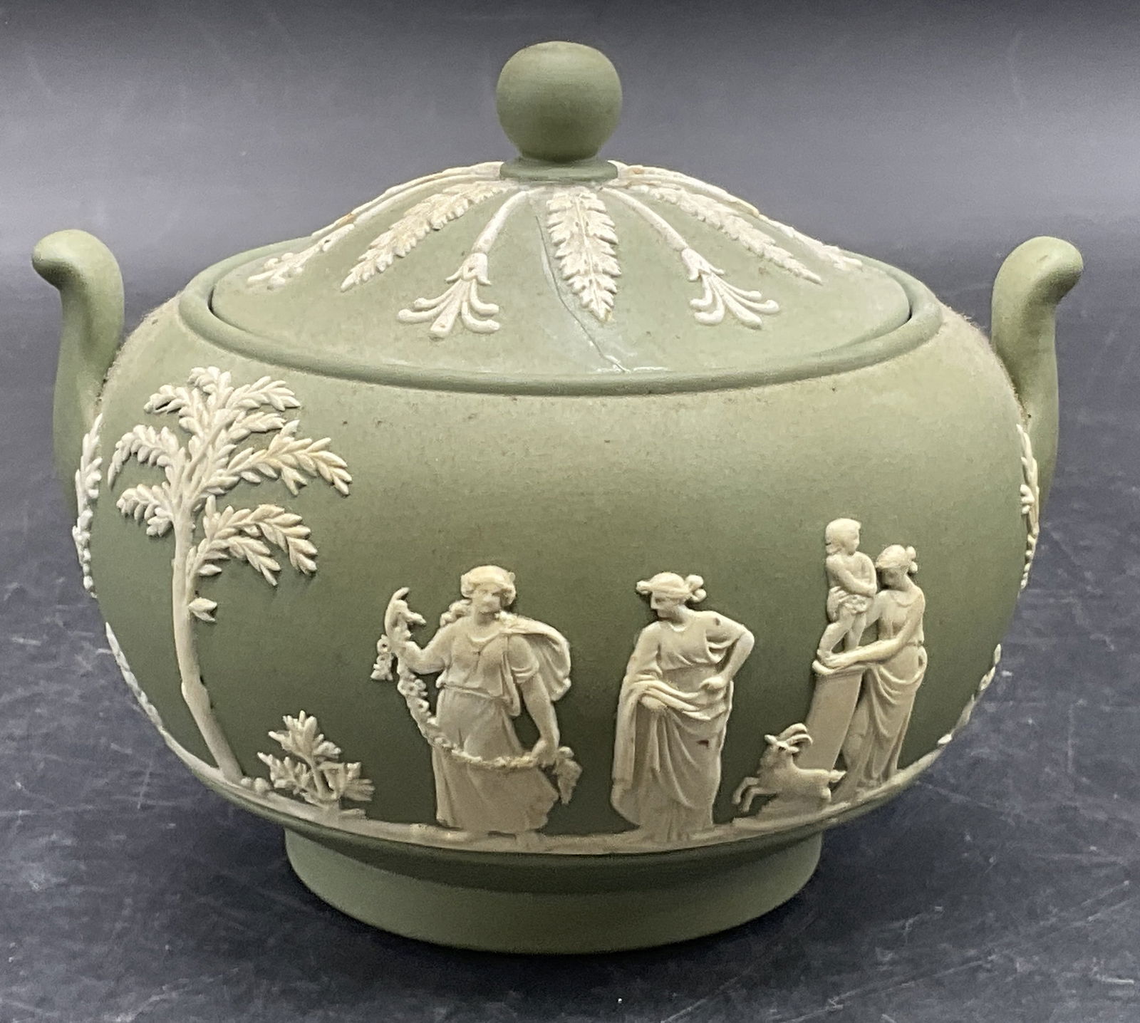 WEDGWOOD ENGLAND Green Jasperware Sugar Bowl: Vintage WEDGWOOD ENGLAND Green Jasperware Sugar Bowl. Underside signed WEDGWOOD MADE IN ENGLAND 1955, possibly reads 1956, verbiage worn. Raised Greco Roman motif along the sides. Measures approx. 4.2