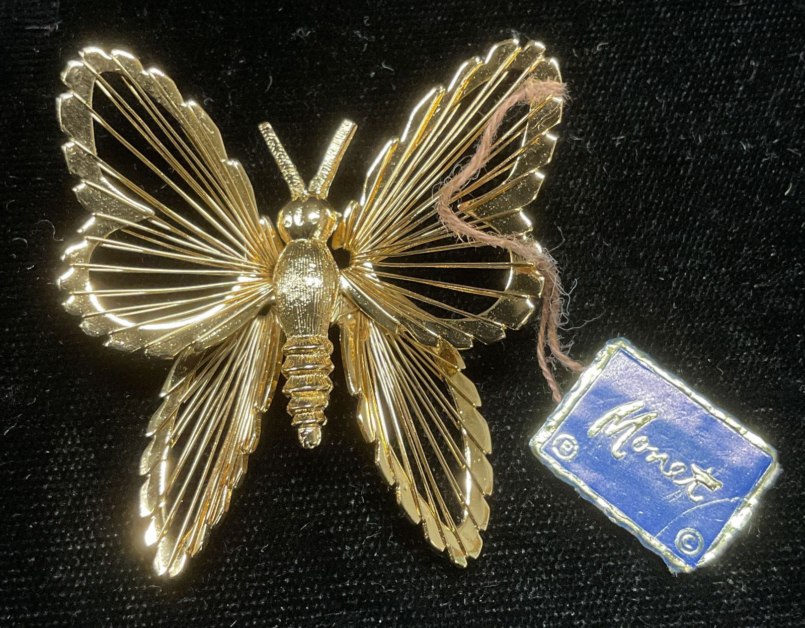 1972 Monet Gold Tone Butterfly Brooch NWT: Vintage 1972 Monet gold tone butterfly motif brooch. Hinge pin on underside. New with tag. Signed on underside. Measures approx 1.75 x 1.75 inches. Some wear including scratching observed. Jewelry, es