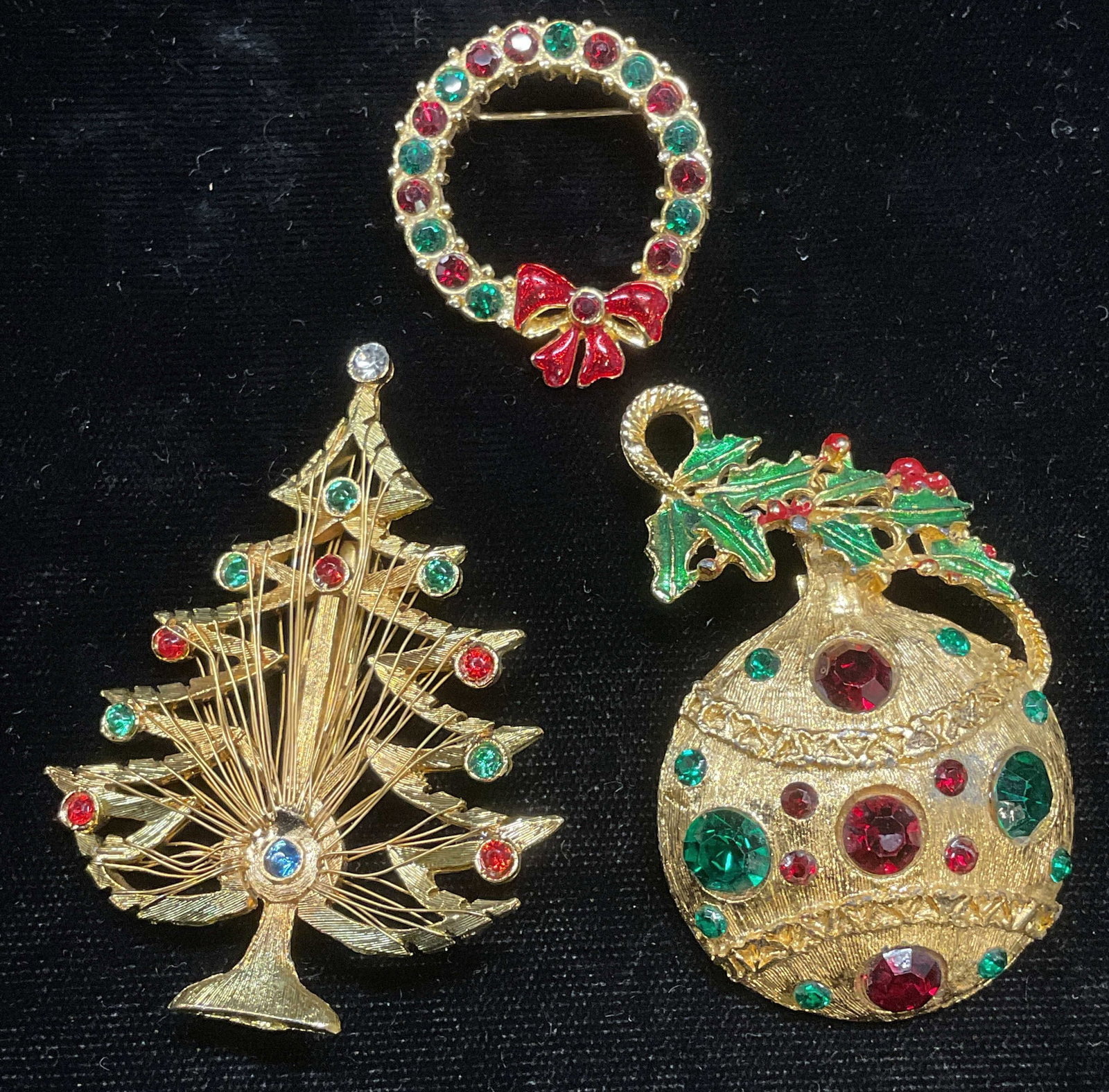 Lot 3 LJM Christmas Tree Brooch, Christmas Jewelry: Lot of 3 pieces of Vince gold tone and crystal Christmas themed brooches. LJM signed Christmas tree motif brooch. Ball ornament motif brooch, and wreath motif brooch. Largest piece approx 2.25 x 1.75 