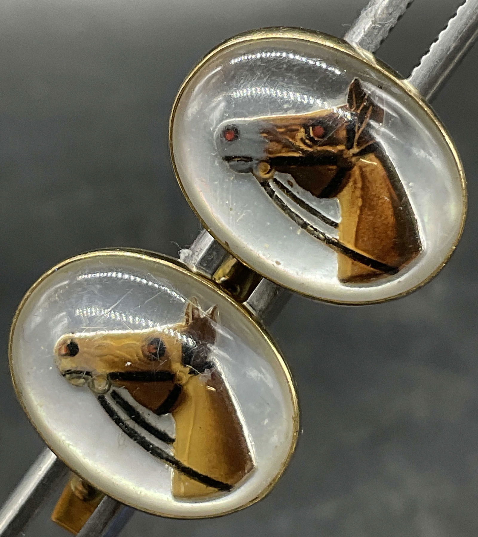 SWANK 10K RGP Horse Head Cuff Links: SWANK 10K RGP Horse Head Cuff Links. Marked SWANK 10K RGP (rolled gold plate). Bezel set colorless faux cabochon with an image of a horse to the center. Costume Cabochon Measures approx. 1W x .5L in.