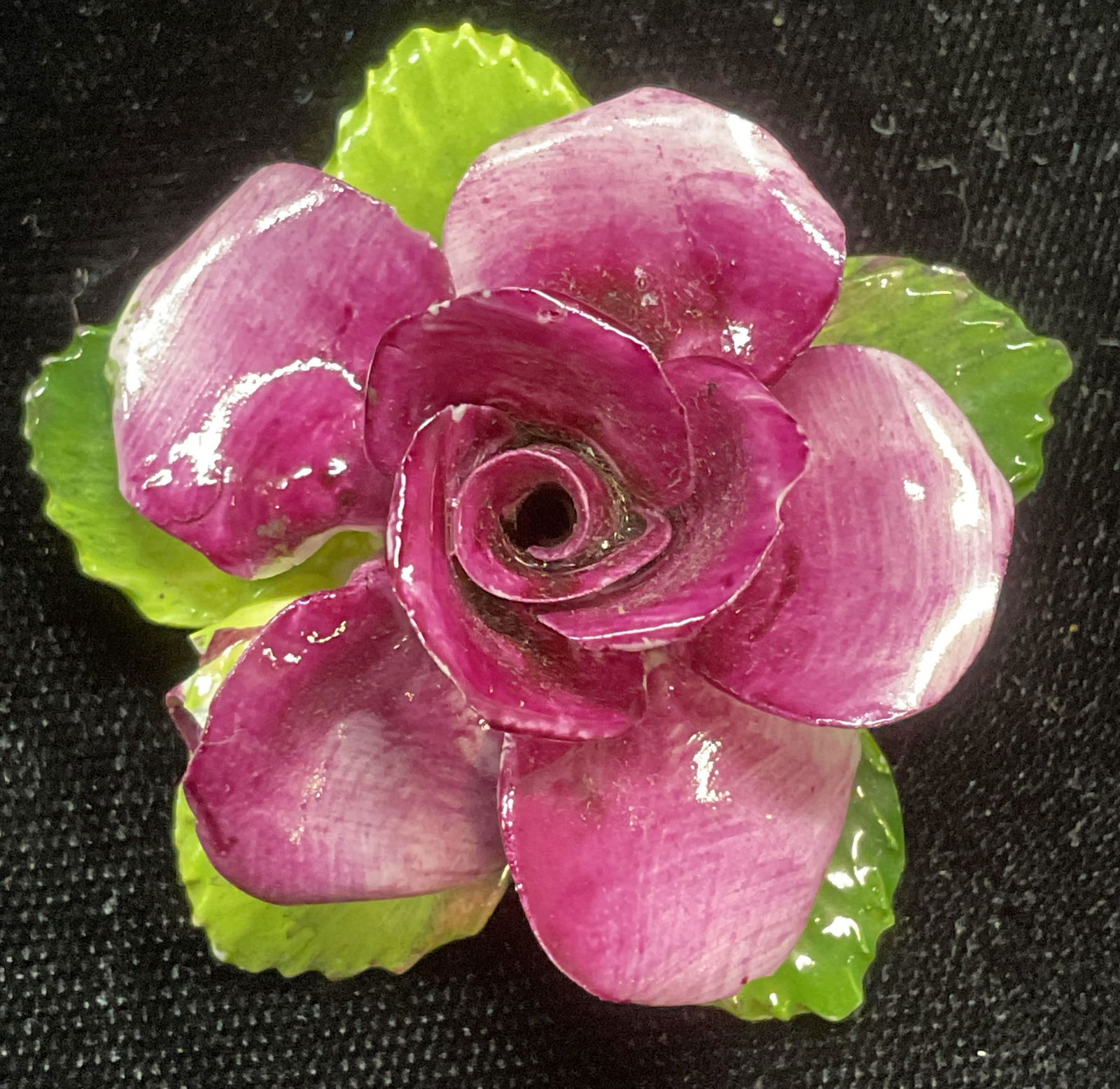 Jon Anton China Flower Brooch, England: Jon Anton bone china flower brooch. Hand painted green and purple. Signed on underside. Made in England. Measures approx 1.75 inches wide. Some wear including scratching and small chips observed. Jewe