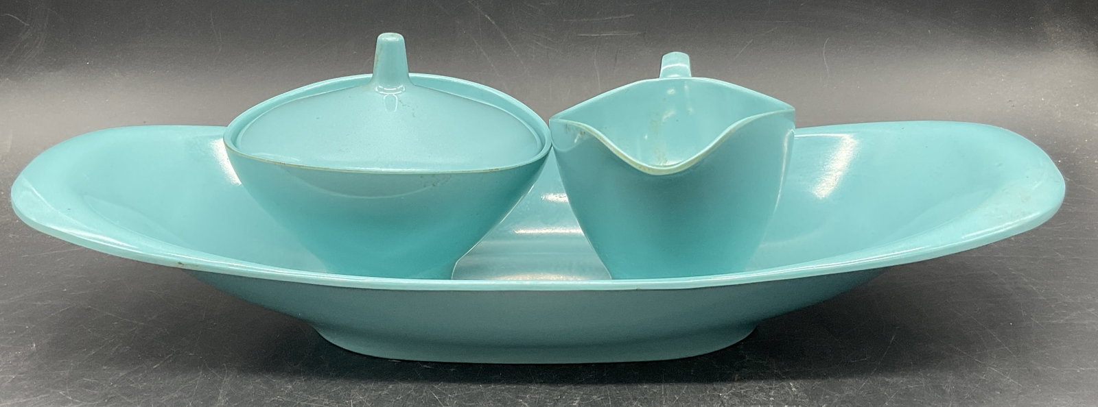 3 BOONTONWARE USA Vintage Blue Melamine Servers: Three pieces of BOONTONWARE USA Vintage Turquoise Blue Melamine Servers. A sugar bowl, a creamer, and a serving bowl. Underside signed BOONTONWARE USA. Largest piece measures approx. 2.5H x 13.5W in. 