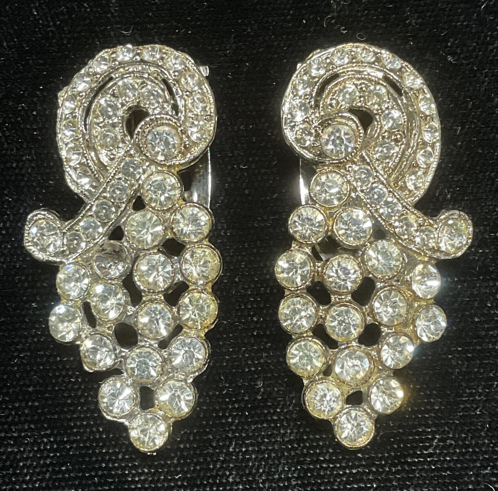 Pair Vintage Crystal Sweater/Dress Clips: Pair of vintage silver tone crystal decorated sweater or dress clips. Measure approx 1.75 x .75 inches each. Some wear to each including scratching observed. One crystal needs replacement. Jewelry, es