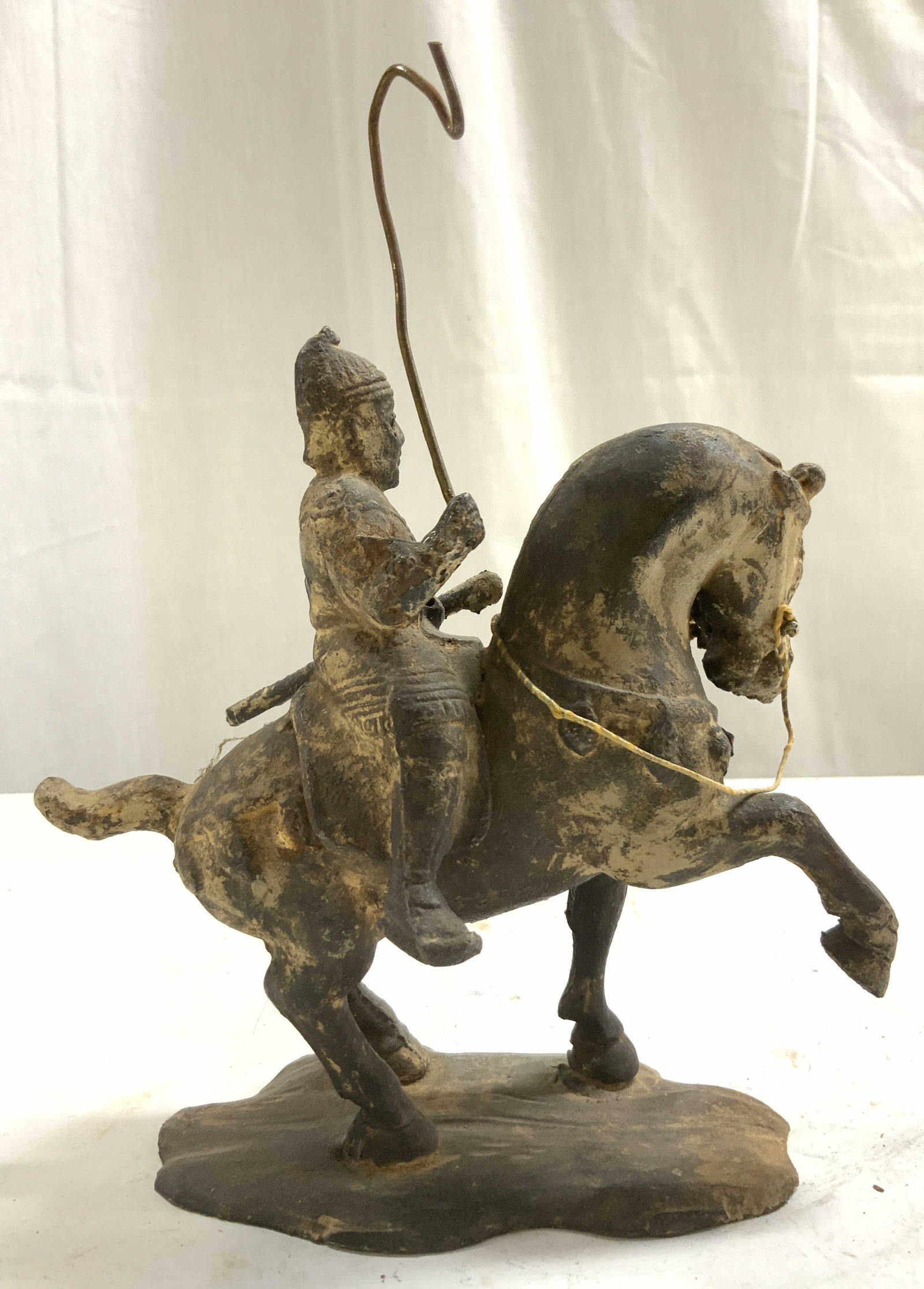 Cast Iron Tang Dynasty Style Warrior On Horseback: Warrior on horseback figure is antique. Piece is Tang Dynasty style. Figure depicts a soldier/ warrior riding horseback. Piece is cast iron. Figure is brown toned. Piece measures approximately 7.5 inc