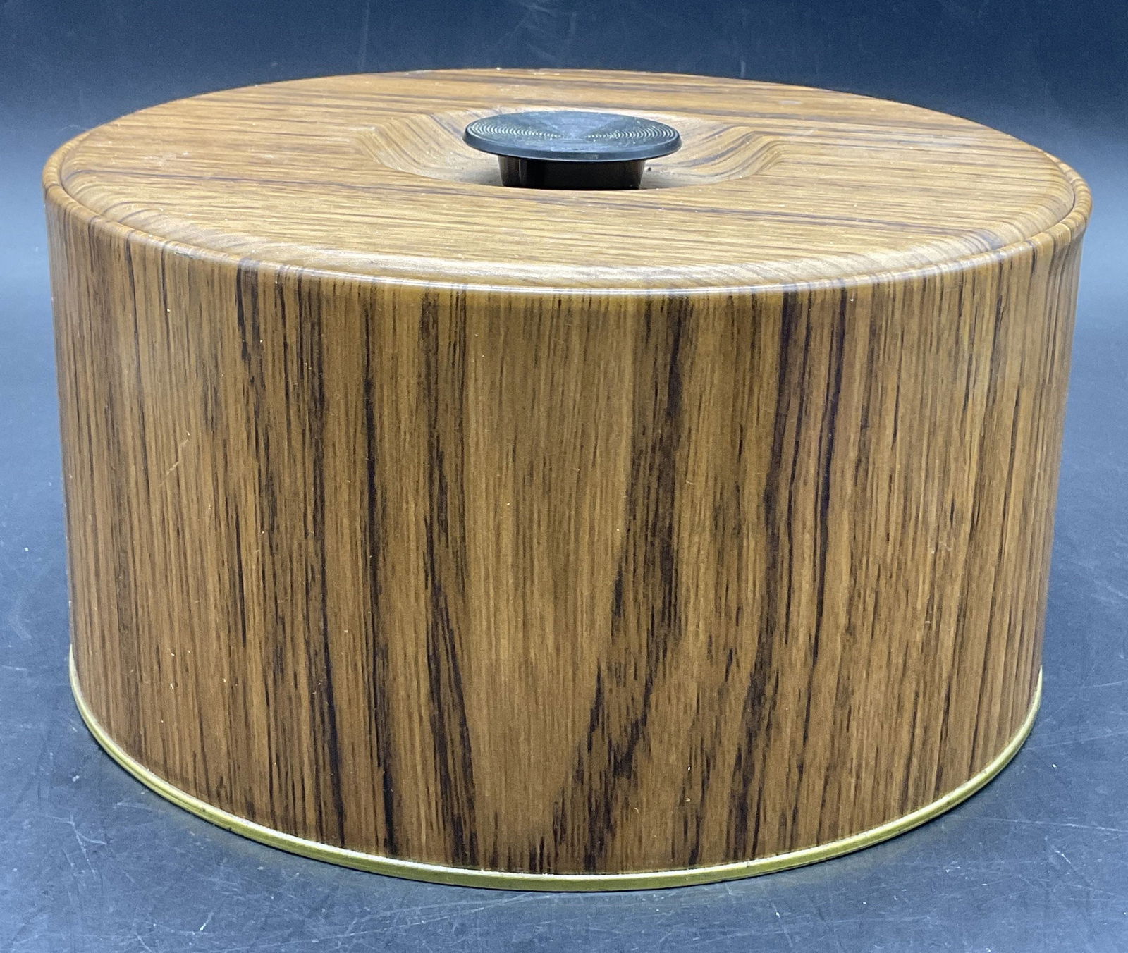 CONTAINER BY GUILDCRAFT NEW YORK USA Lidded Box: Vintage Faux Wood CONTAINER BY GUILDCRAFT NEW YORK USA Lidded Box. Crafted from metal and plastic. Measures approx. 4.25H x 8W in. Underside reads CONTAINER BY GUILDCRAFT NEW YORK USA. Discoloration,